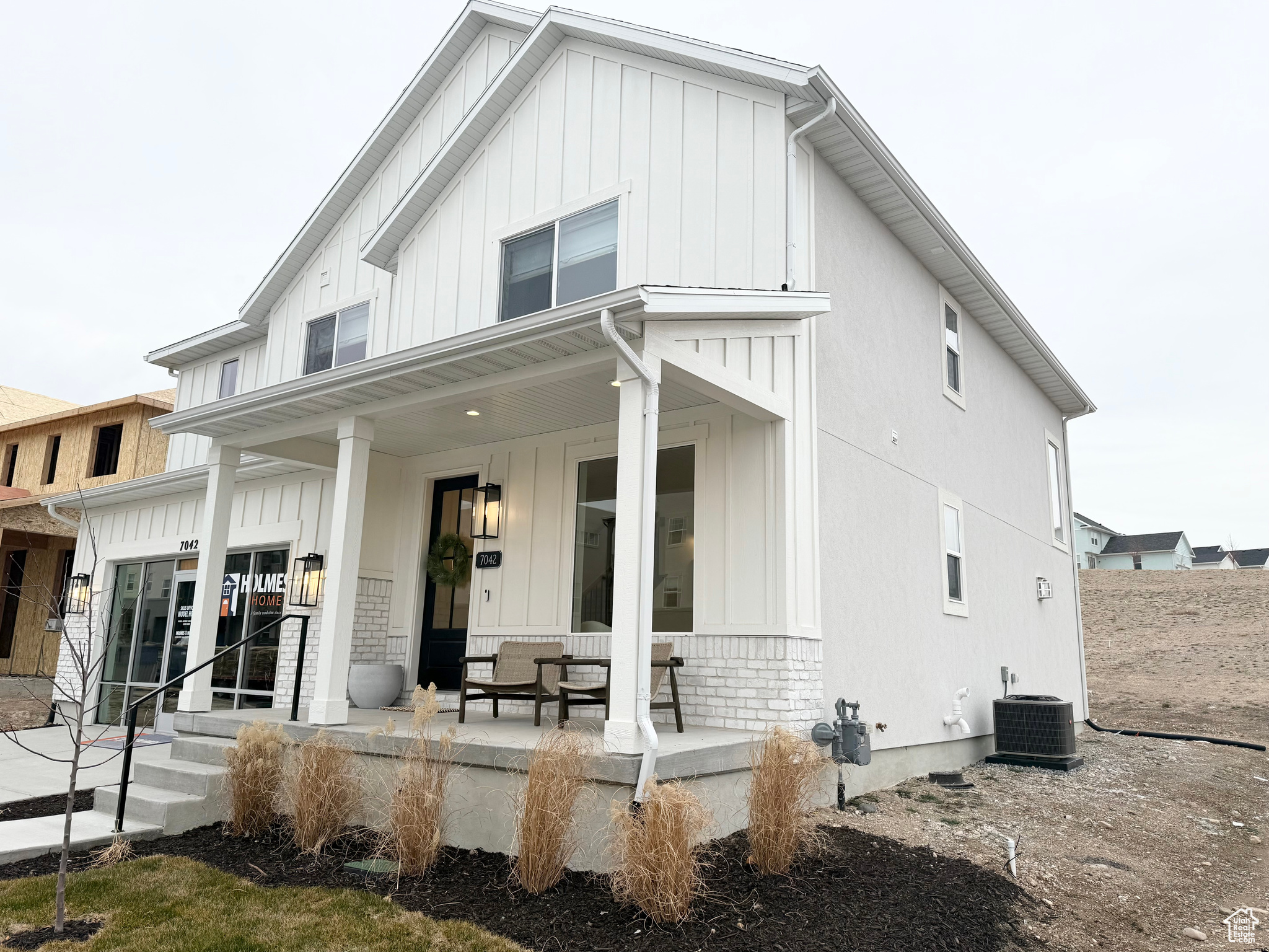 Rear view of property featuring covered porch and central AC unit