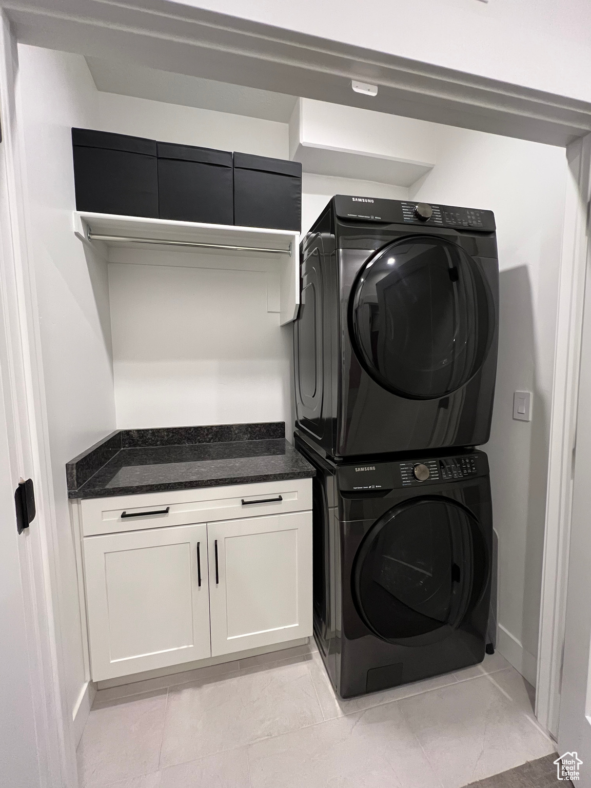 Laundry area featuring stacked washer / dryer and custom cabinetry