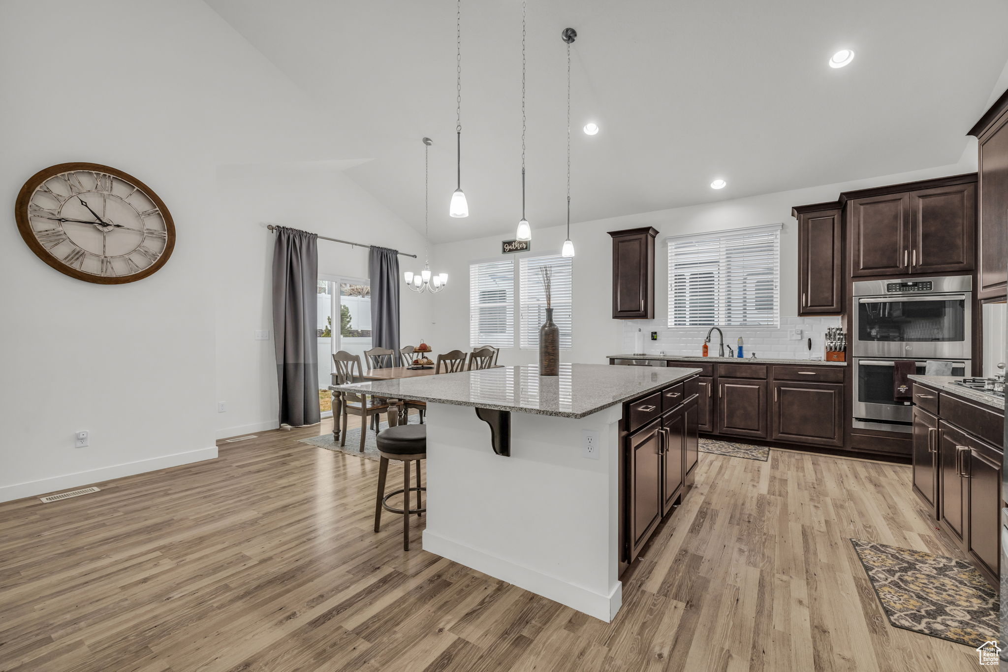 Kitchen with center island, stainless steel double oven, and a kitchen breakfast bar