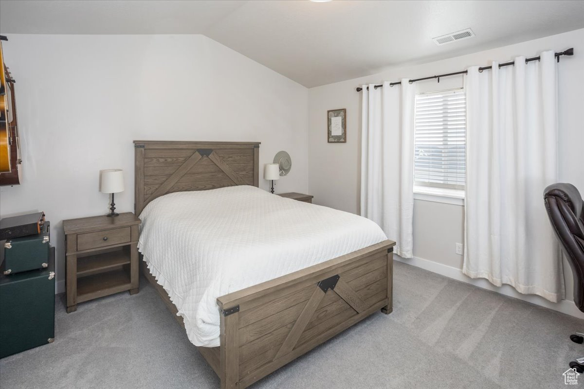 Carpeted bedroom with vaulted ceiling