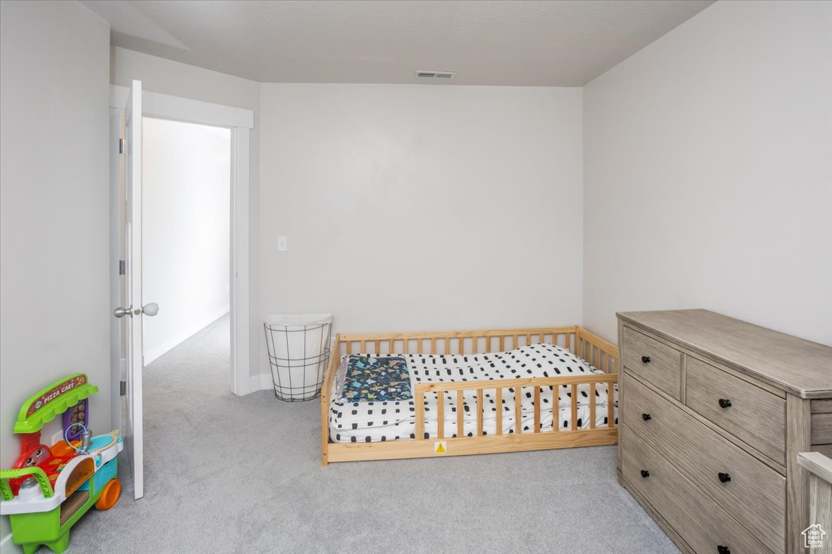 Carpeted bedroom featuring a crib