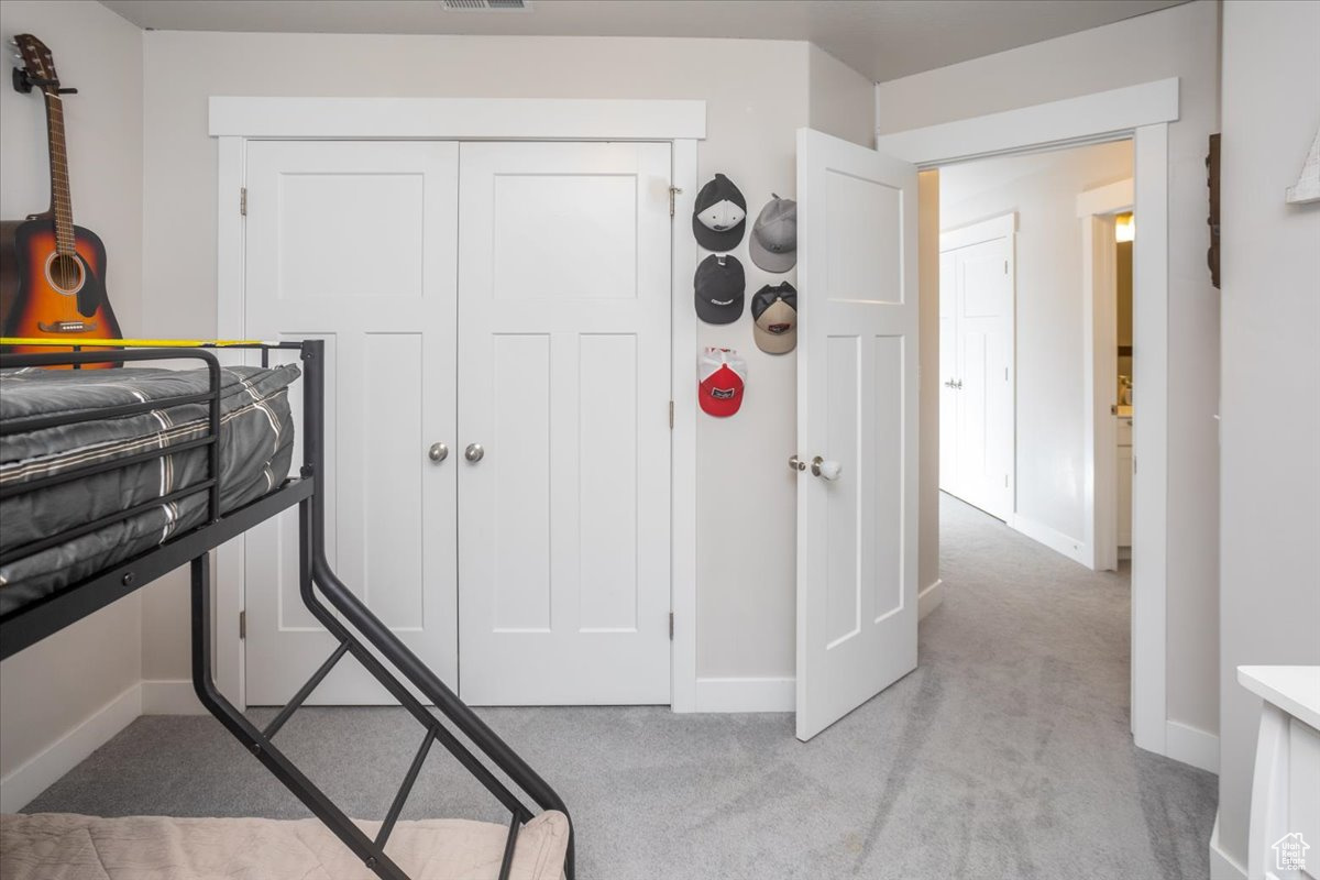 Carpeted bedroom featuring a closet