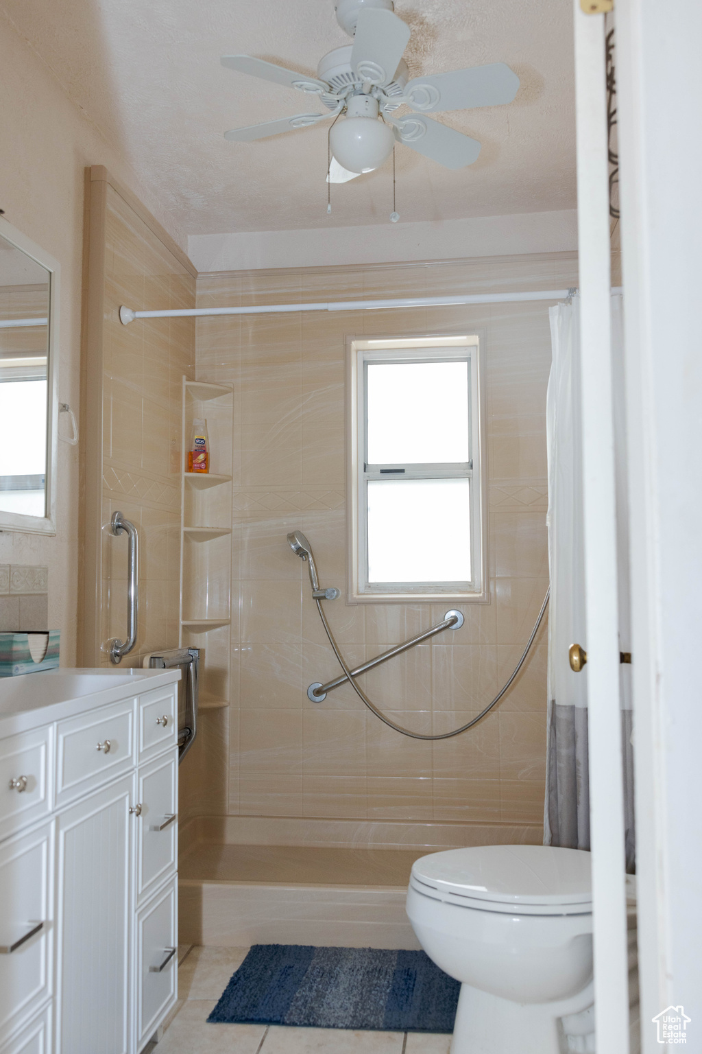 Bathroom with tile patterned floors, ceiling fan, plenty of natural light, and walk in shower