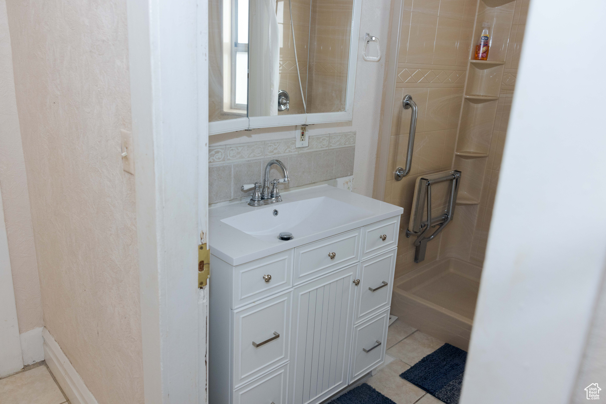 Bathroom with tile patterned flooring, vanity, and walk in shower