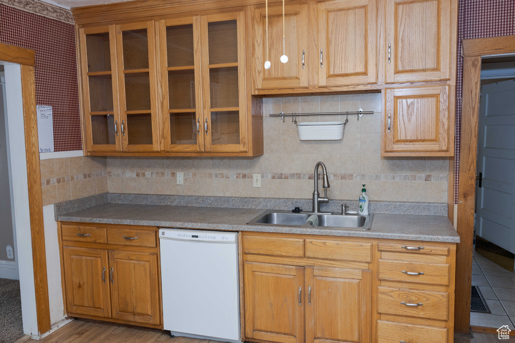 Kitchen featuring white dishwasher and sink