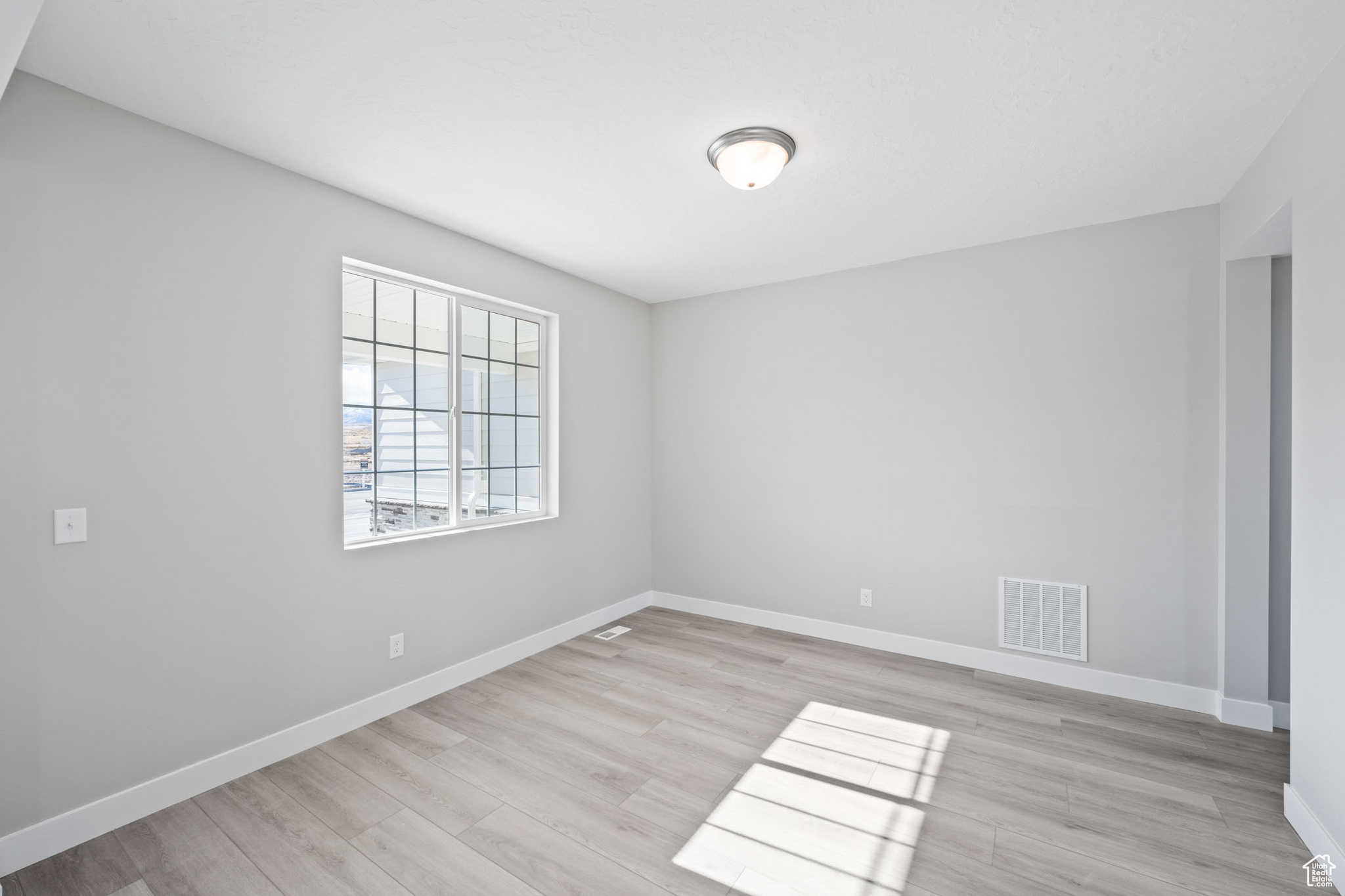 Empty room with light hardwood / wood-style floors