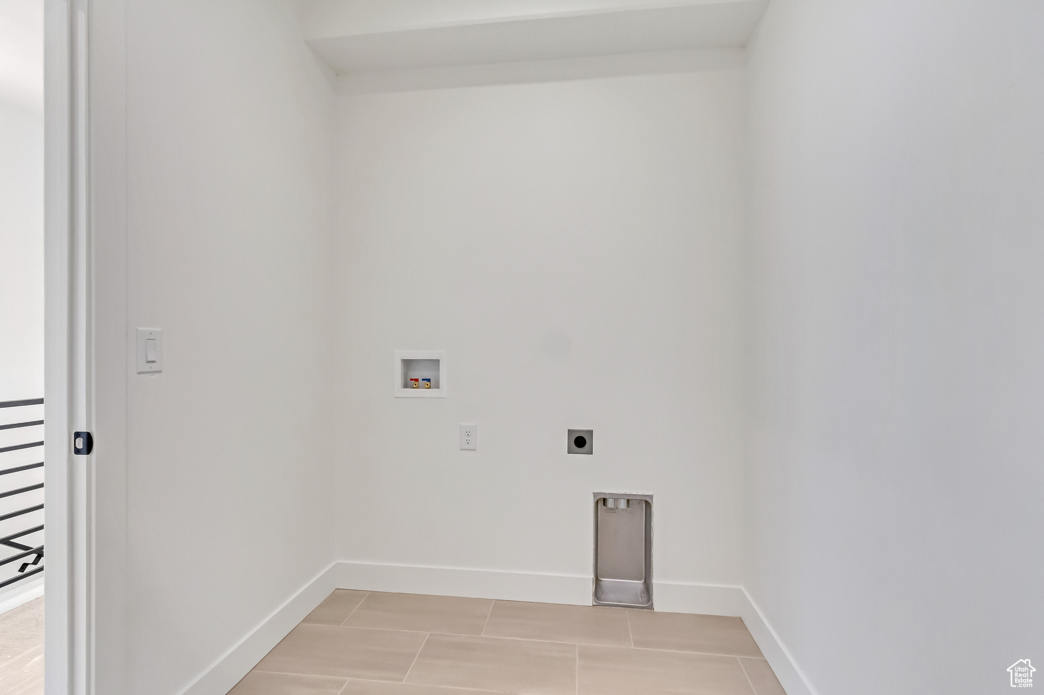 Laundry area with electric dryer hookup, light tile patterned floors, and washer hookup