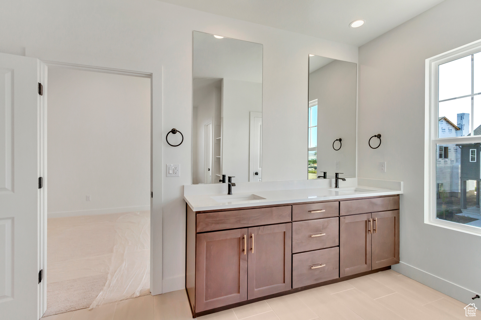 Bathroom with vanity, tile patterned floors, and a healthy amount of sunlight