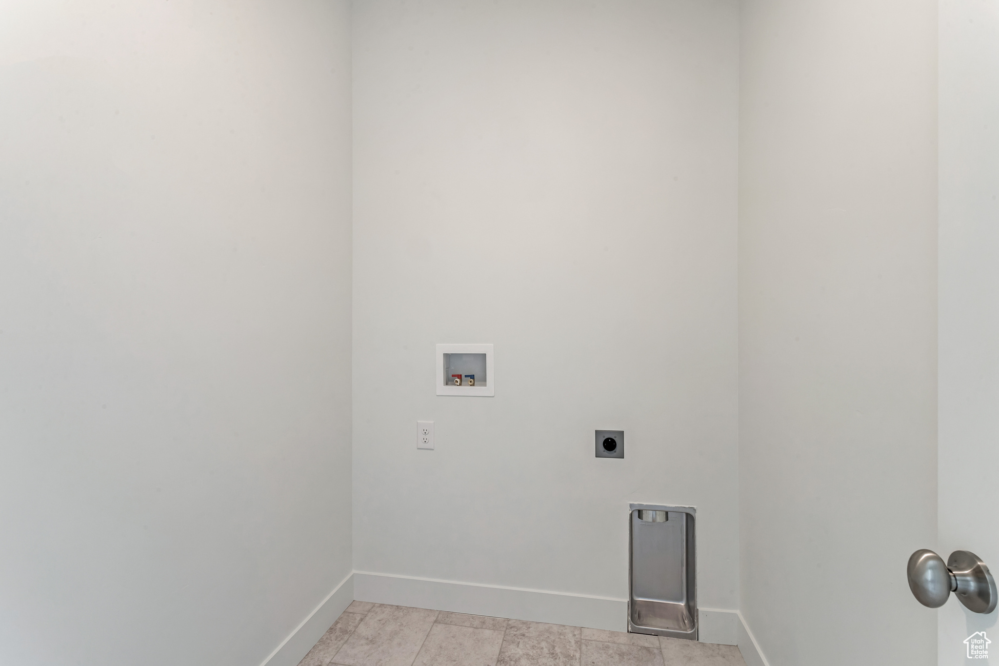 Clothes washing area featuring washer hookup and hookup for an electric dryer