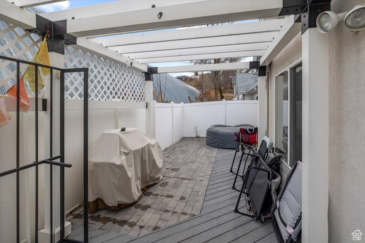 Deck with a pergola and area for grilling