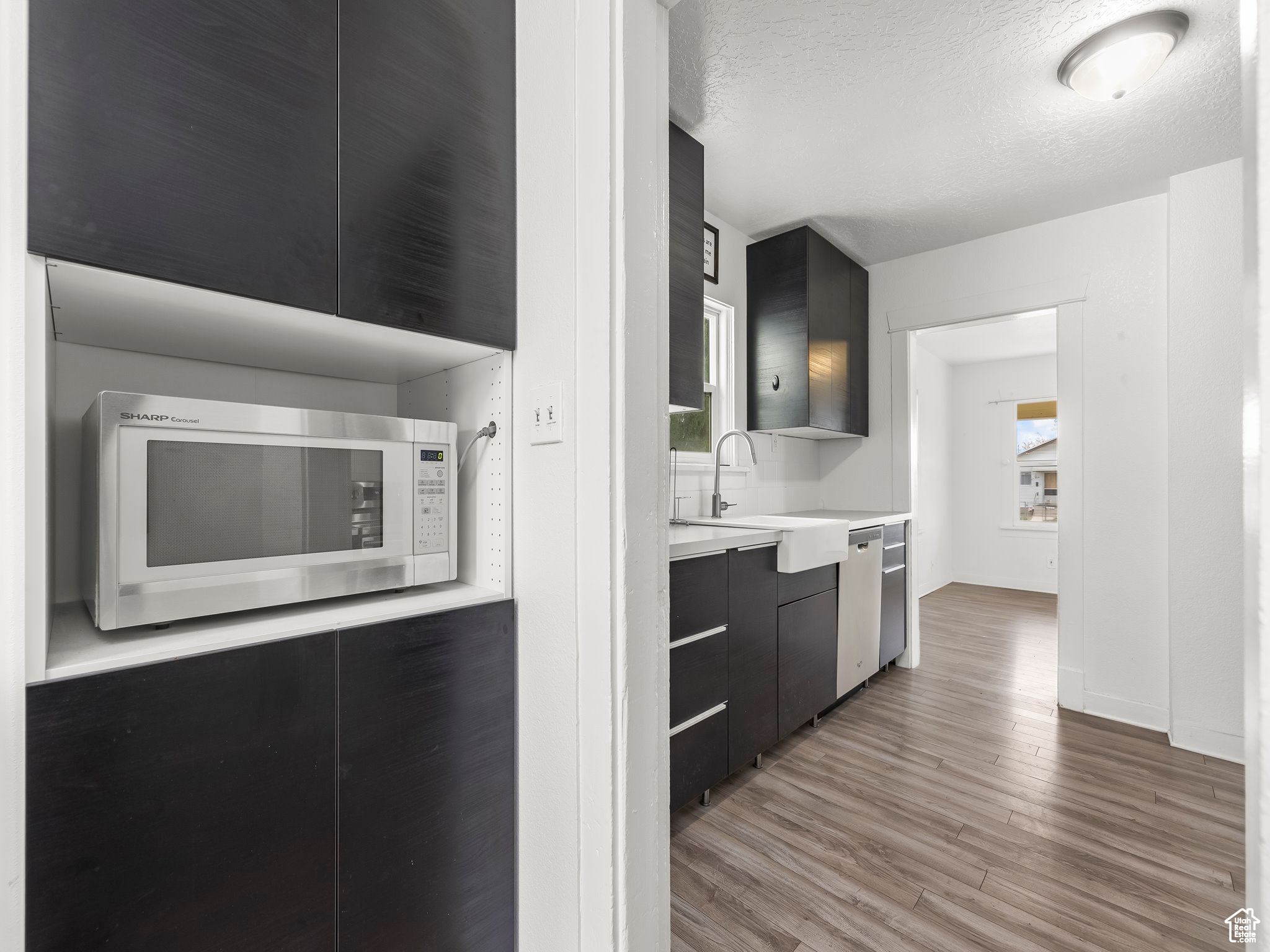 Kitchen featuring a textured ceiling, wood-type flooring, and sink