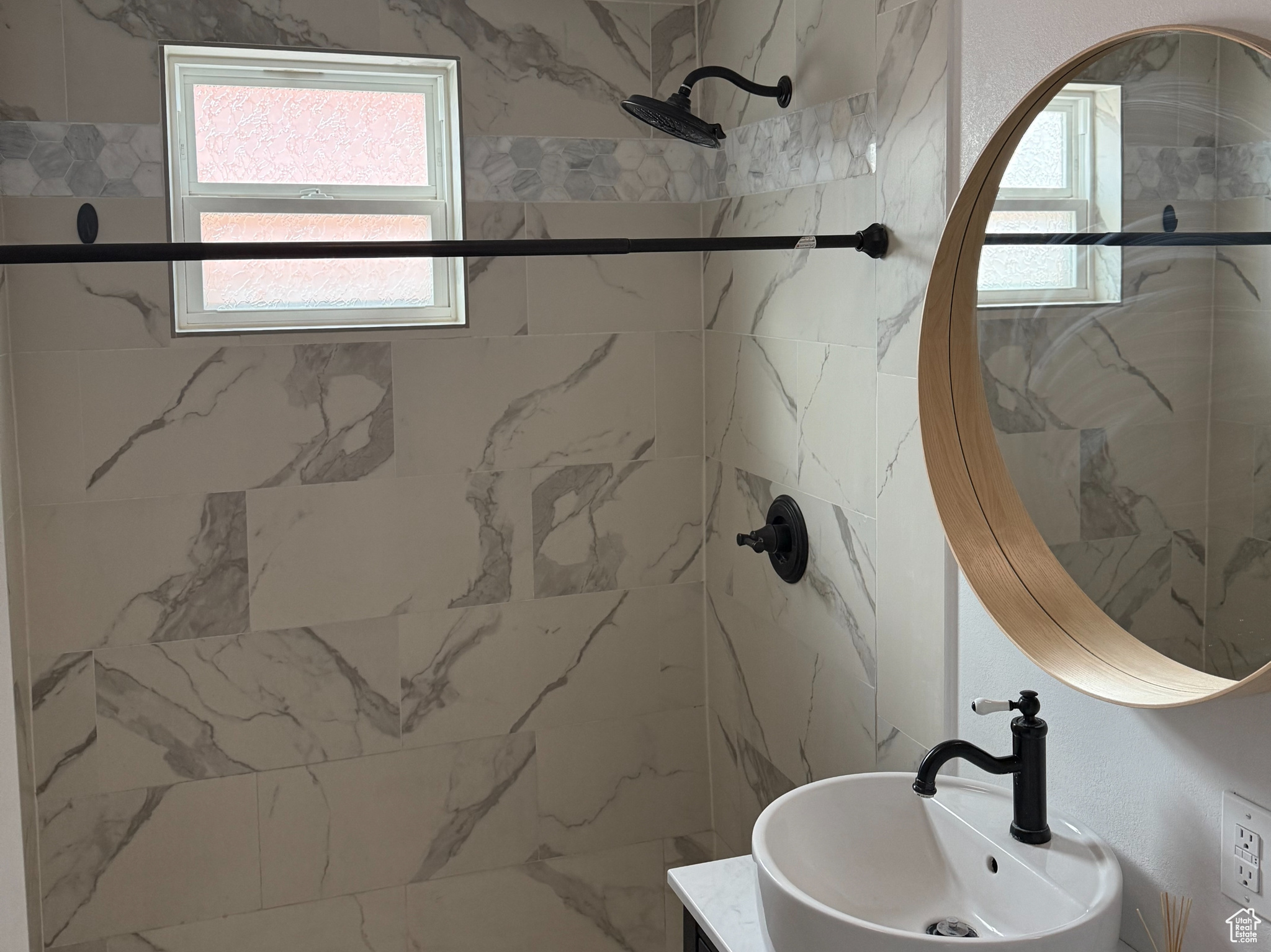 Bathroom with tiled shower, vanity, and a textured ceiling