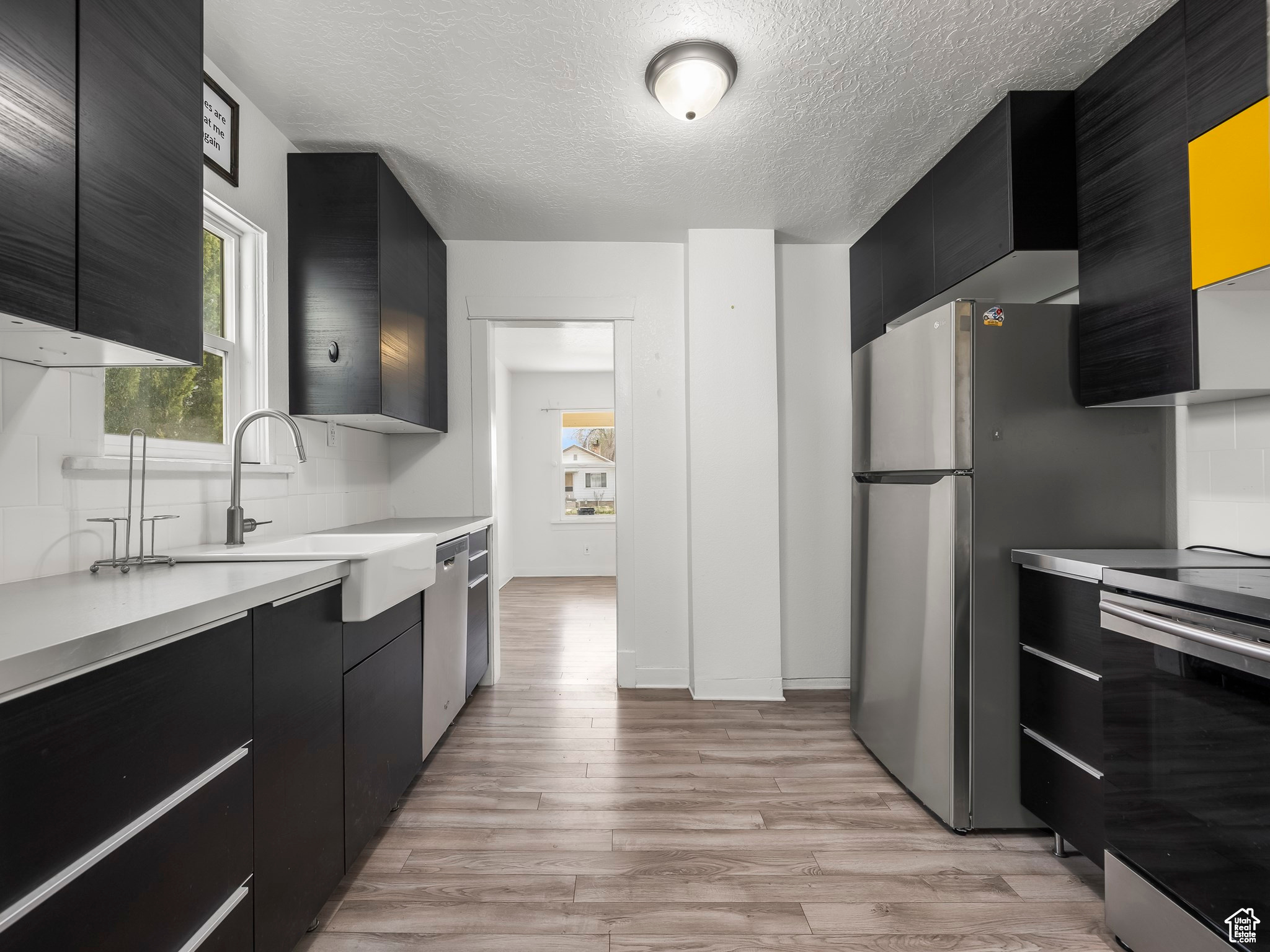 Kitchen with a healthy amount of sunlight, sink, stainless steel appliances, and light wood-type flooring