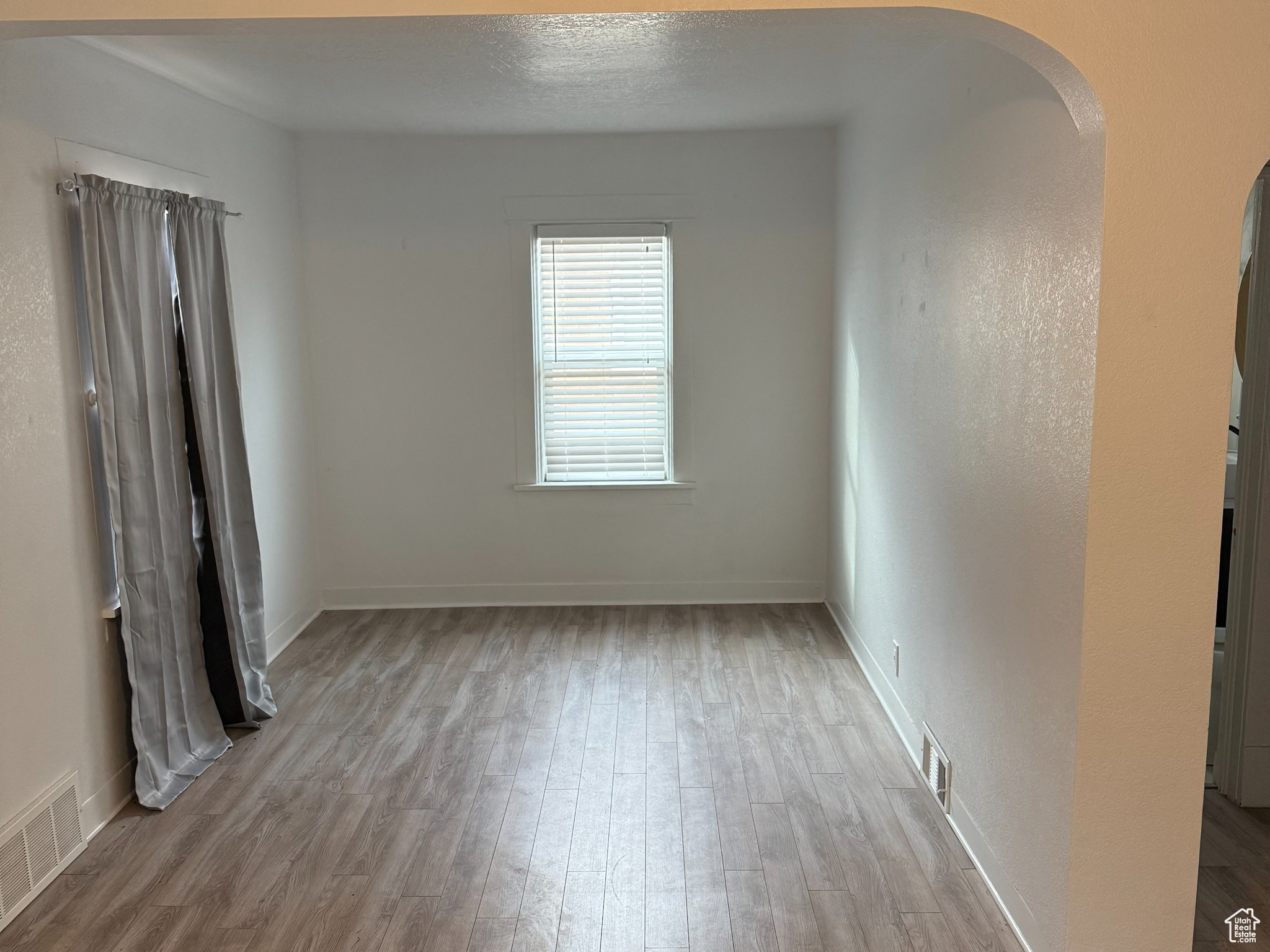 Unfurnished room featuring wood-type flooring and a textured ceiling