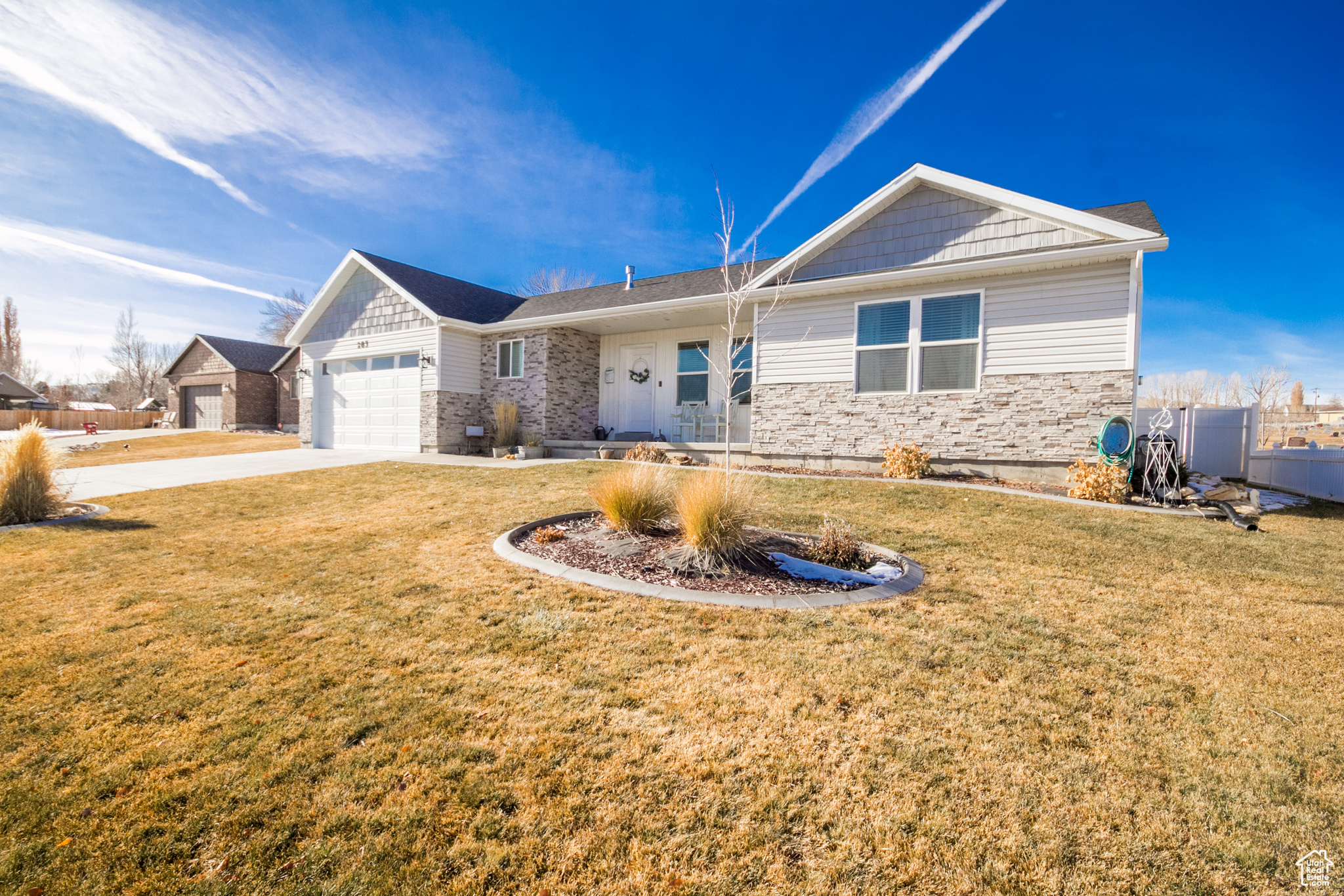 Ranch-style home with a garage and a front lawn