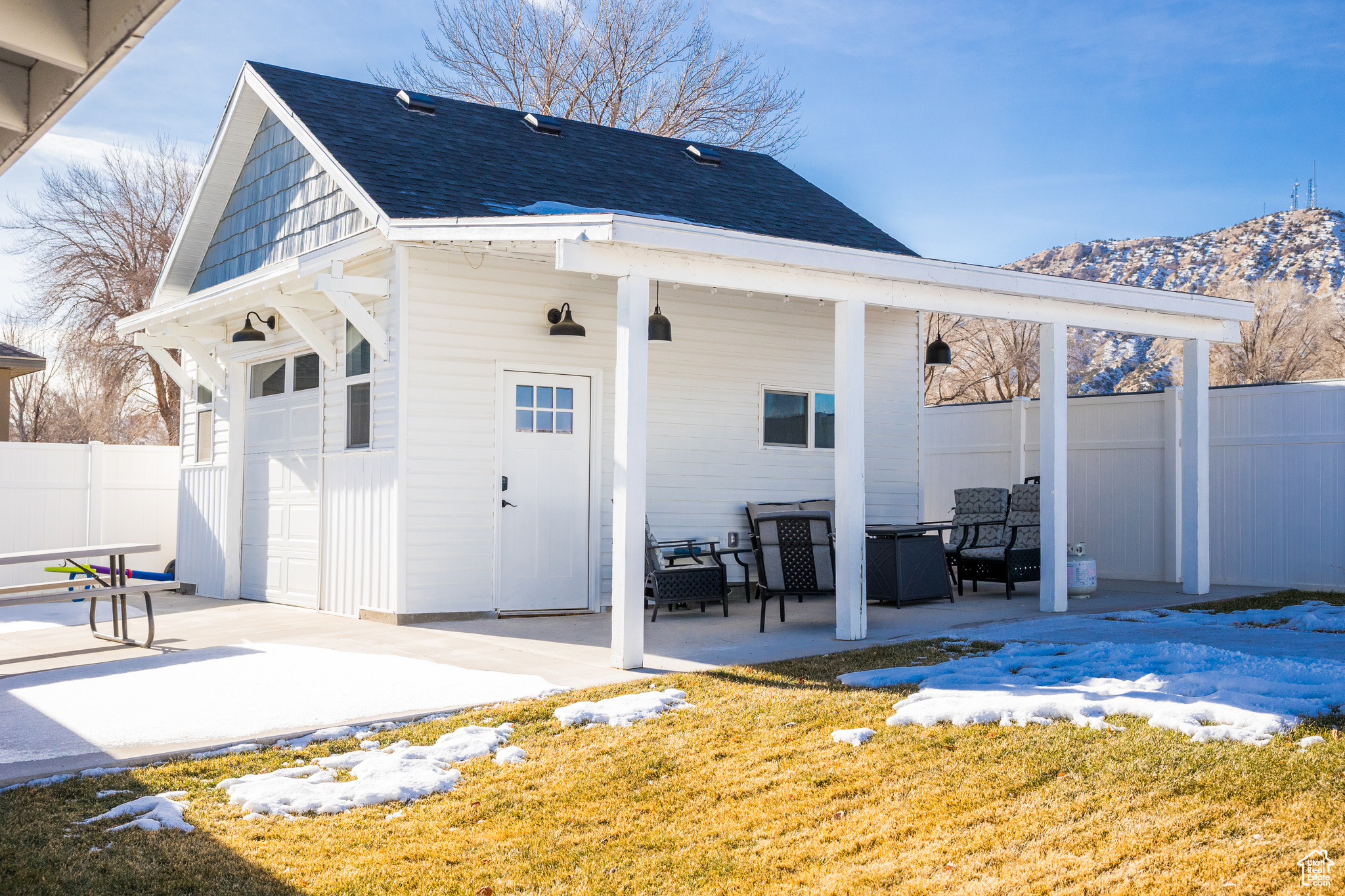 Back of property with a yard, an outbuilding, a patio, and a garage