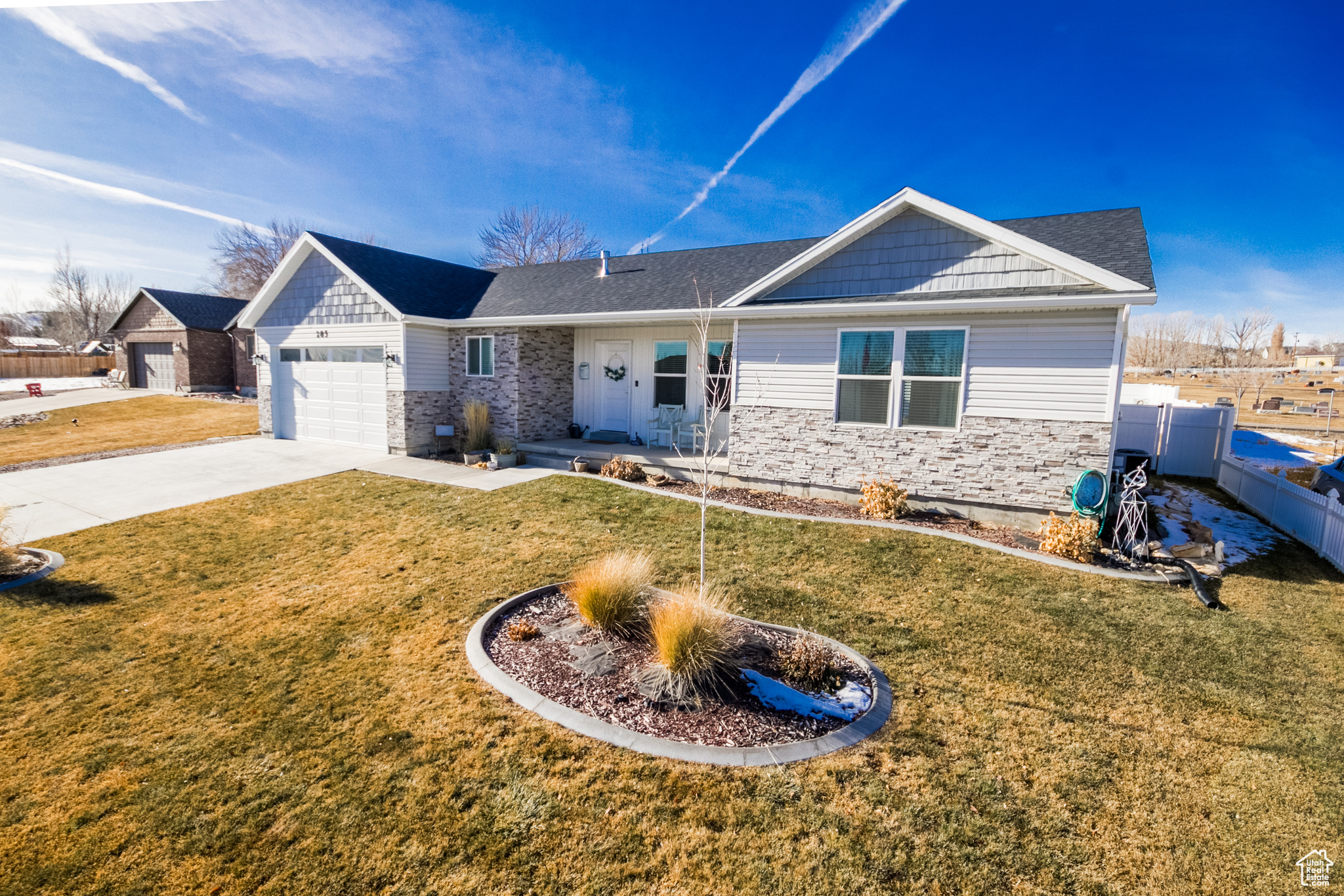 Single story home with a garage and a front lawn