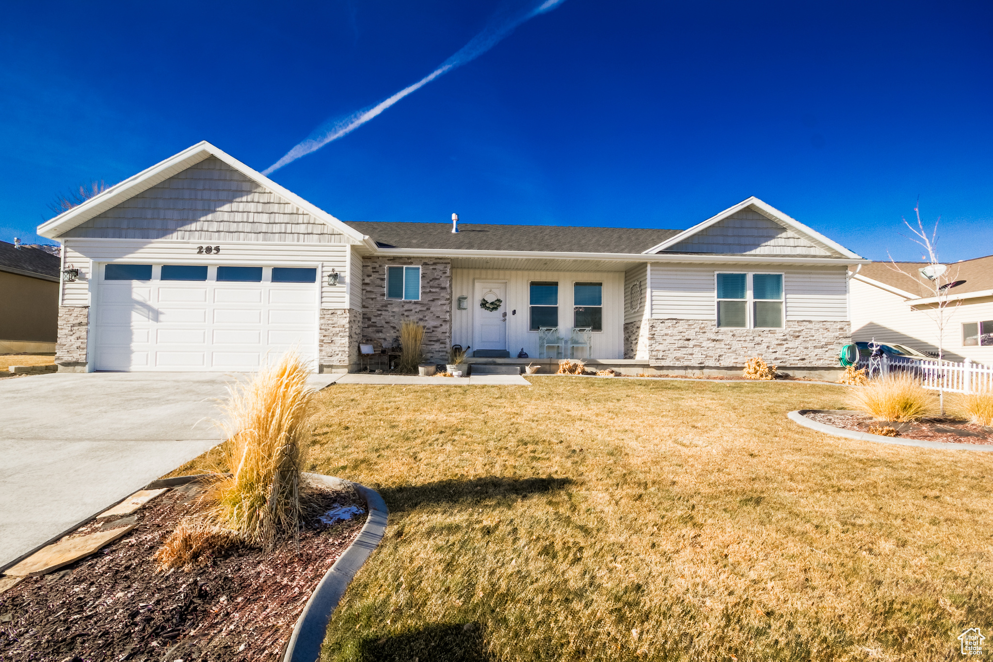 View of front of house featuring a front lawn and a garage