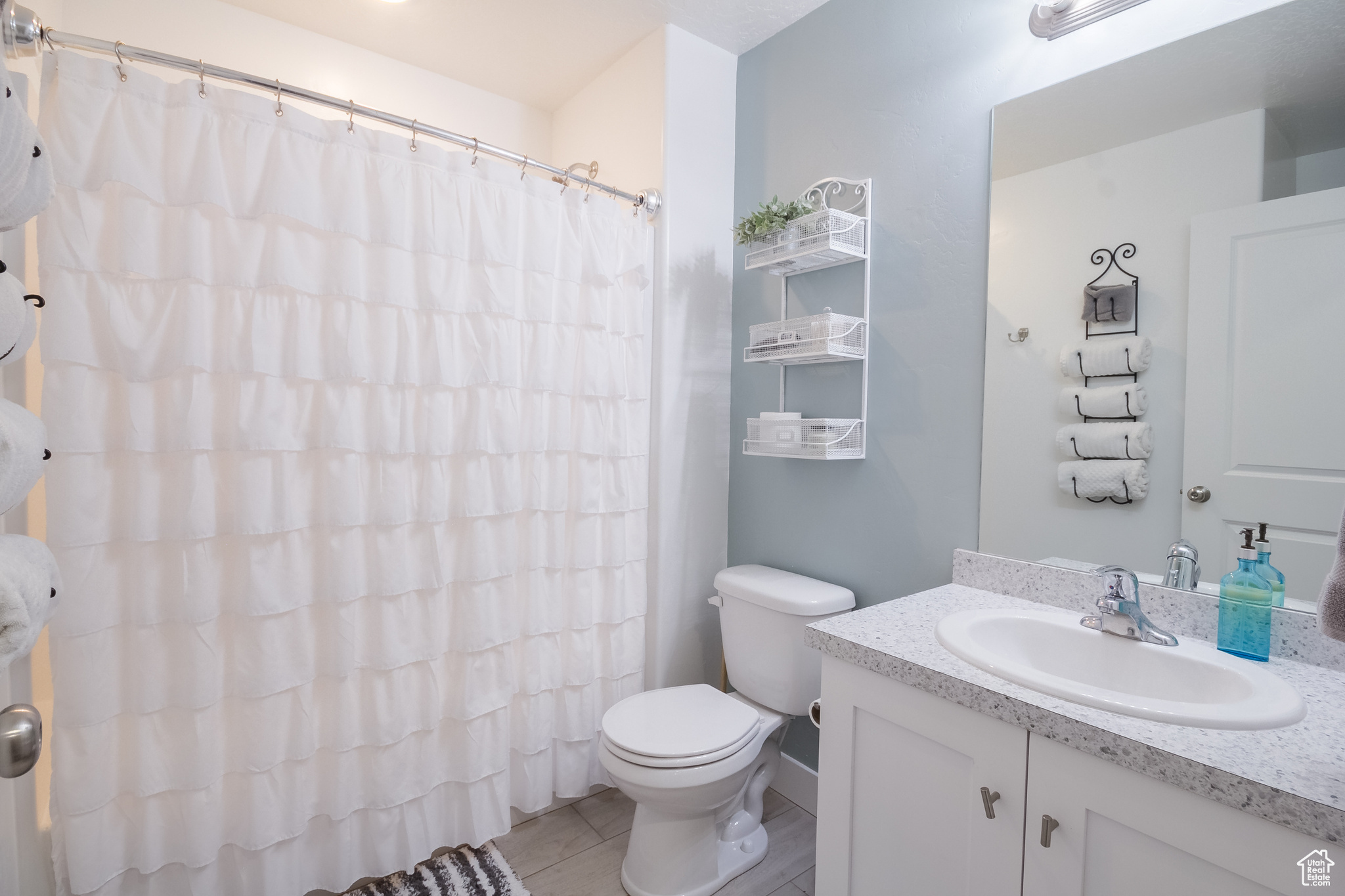 Bathroom featuring tile patterned flooring, vanity, a shower with shower curtain, and toilet