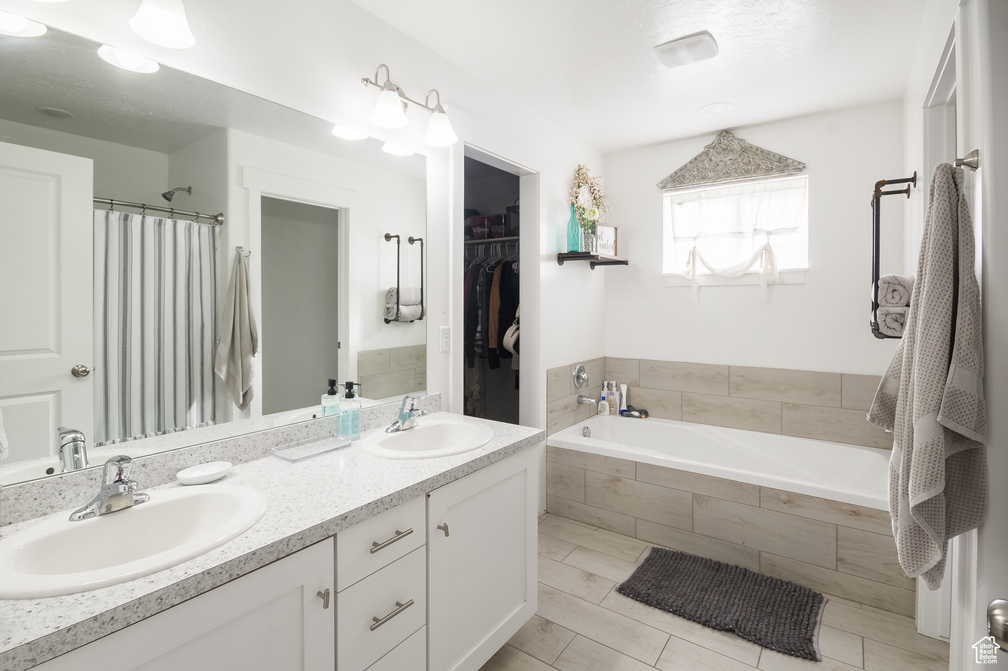 Bathroom with vanity and tiled tub