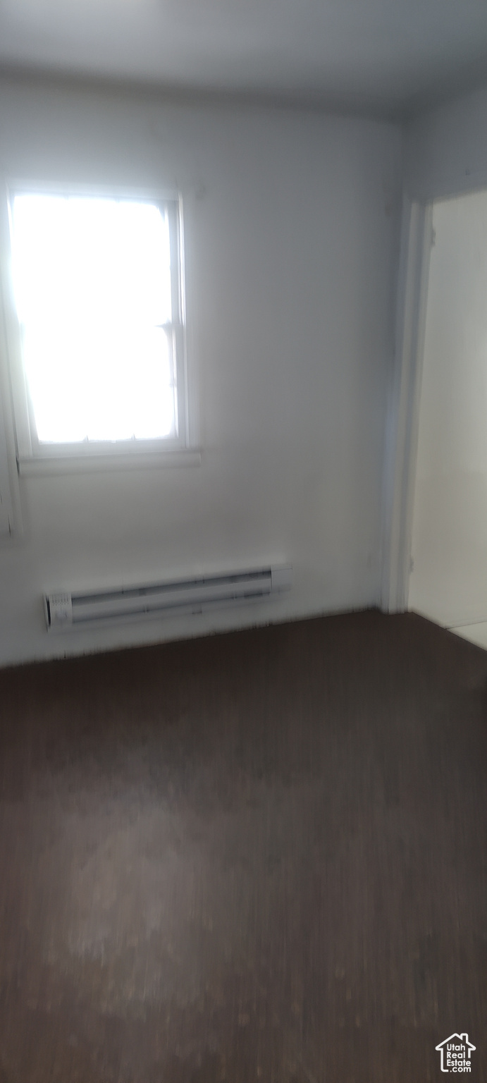 Empty room featuring a baseboard heating unit