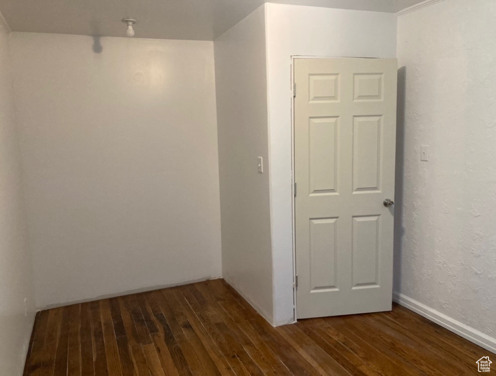 Unfurnished room with dark hardwood / wood-style floors and crown molding