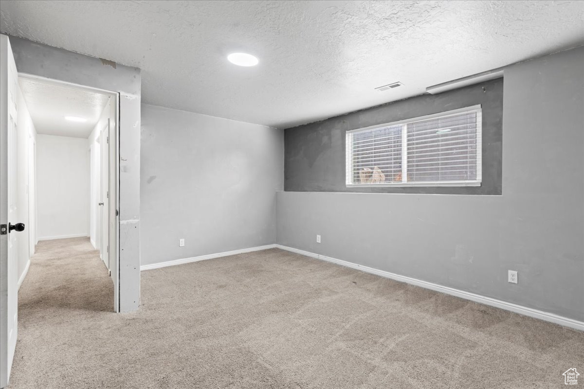 Carpeted empty room with a textured ceiling