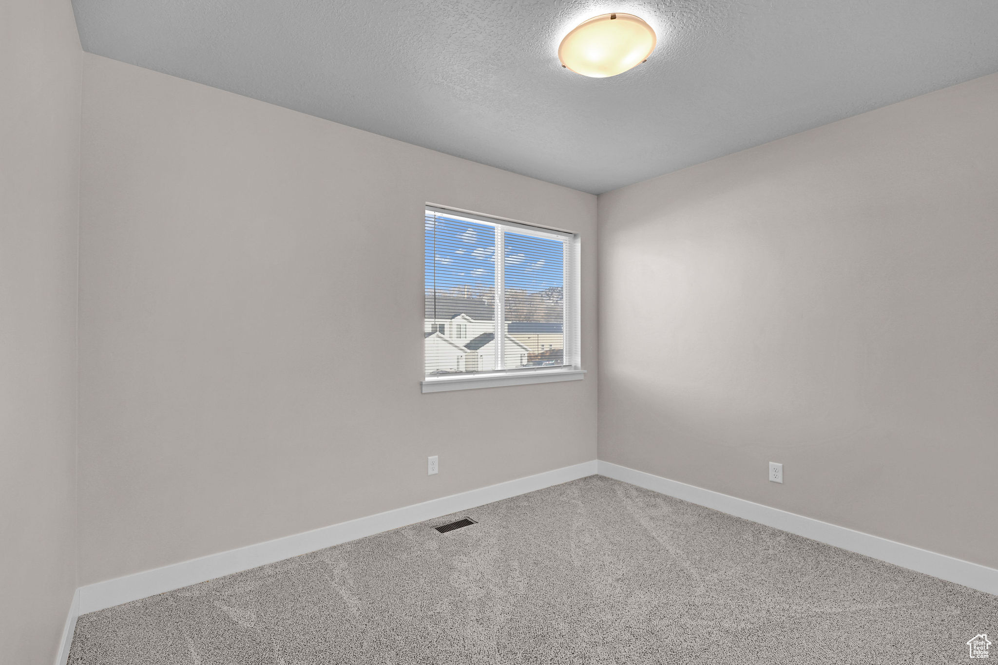 Unfurnished room featuring carpet floors and a textured ceiling