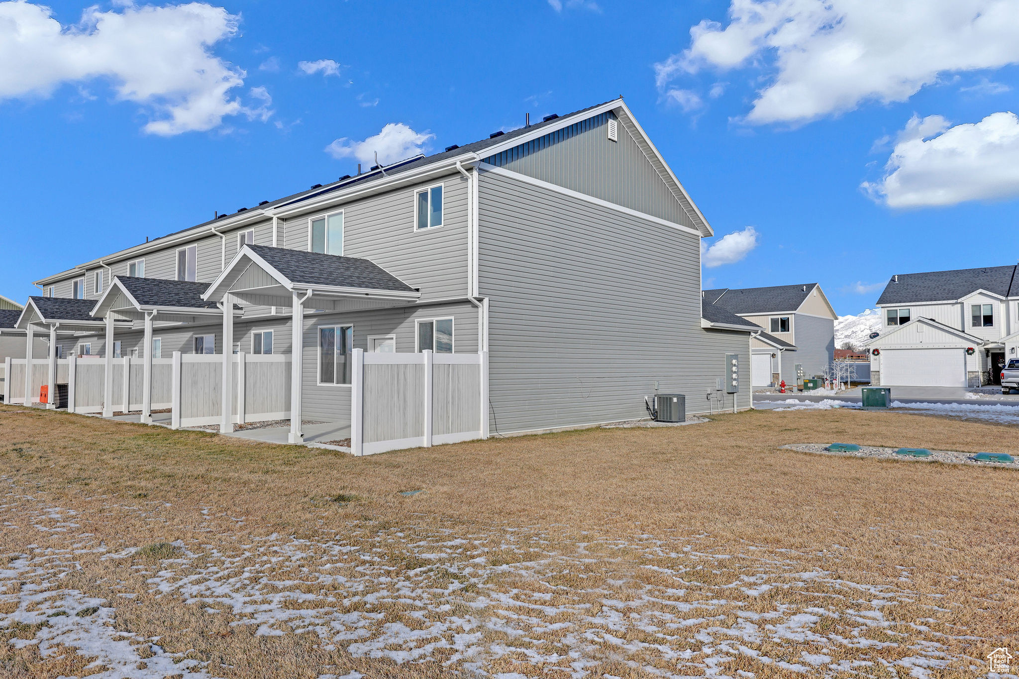 Snow covered property with central AC unit