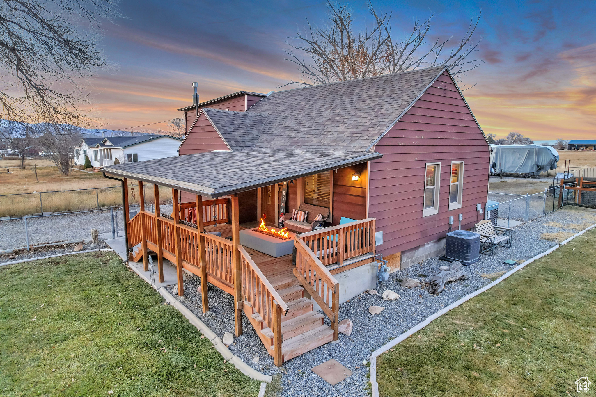 Front deck at dusk featuring outdoor lounge area and grass,  fully fenced yard