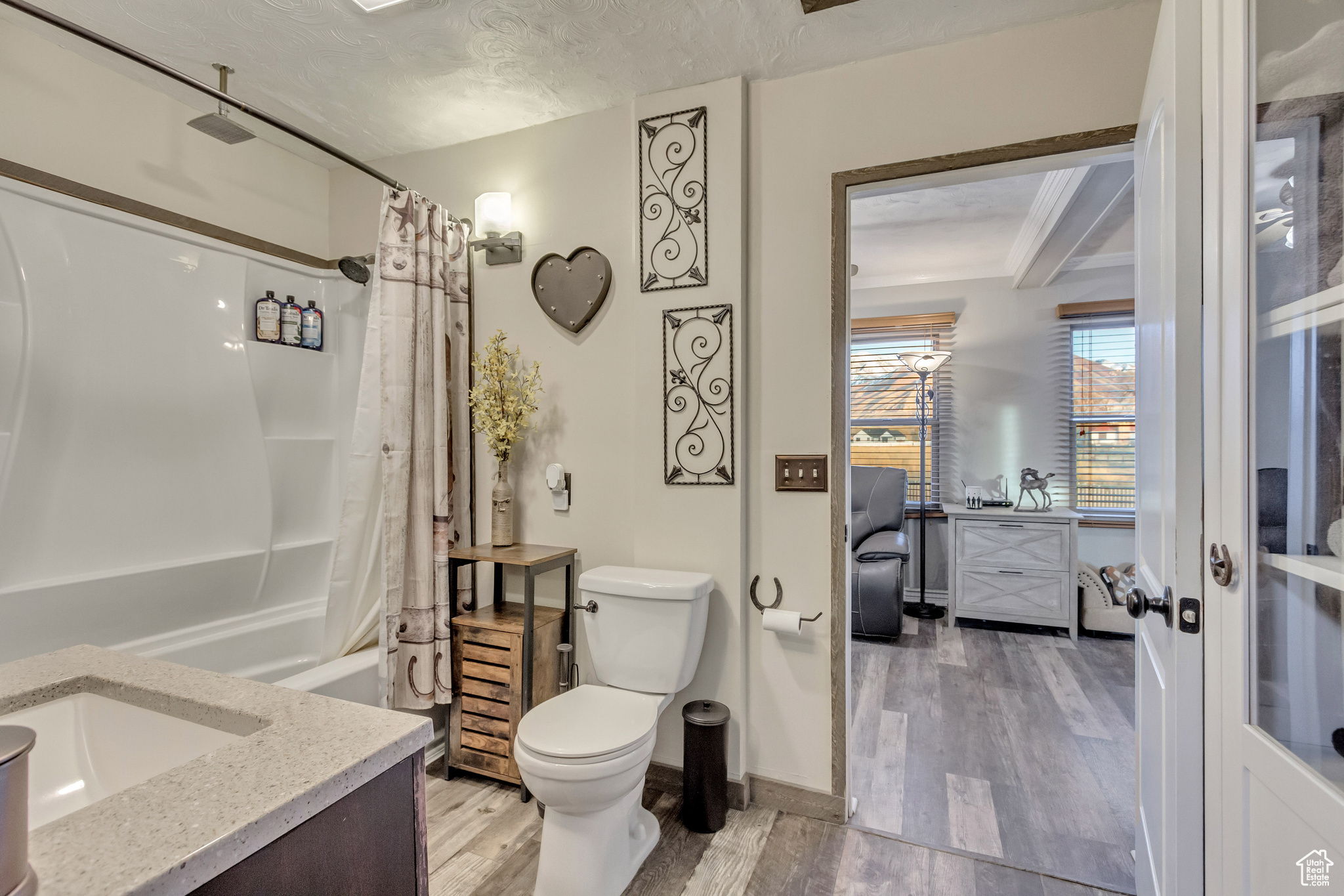 Full bathroom featuring shower / bath combo, LVP flooring, updated fixtures