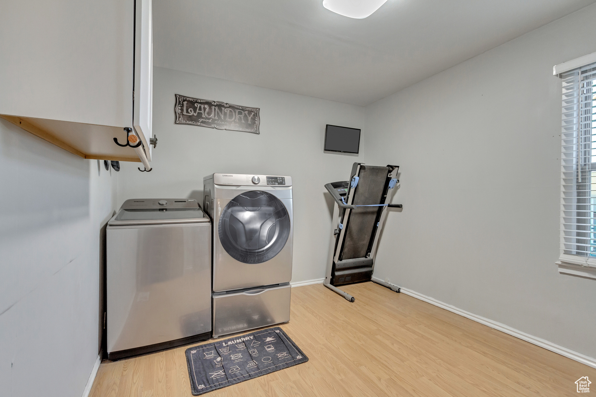 Laundry room with light hardwood / wood-style flooring