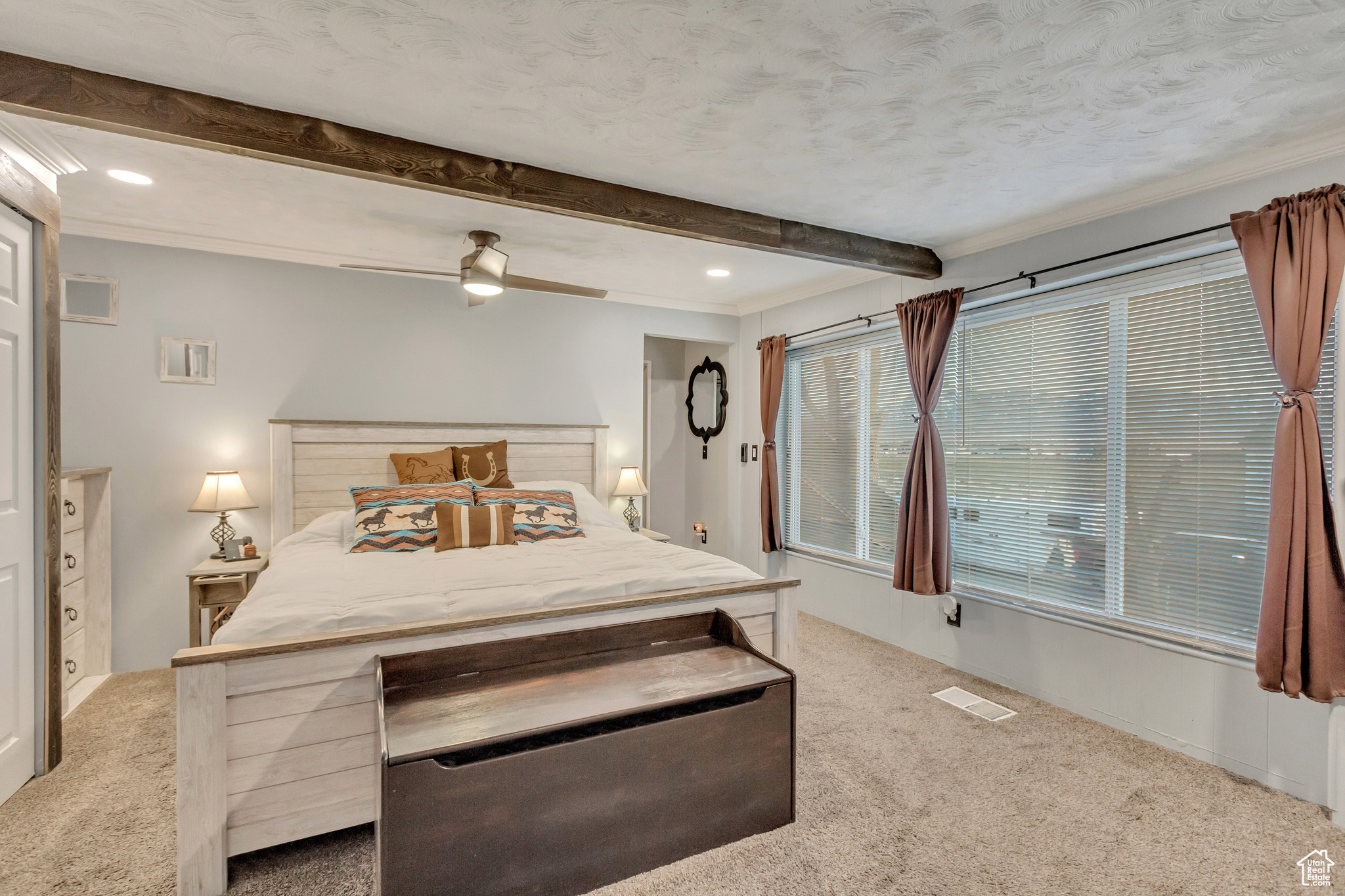 Primary bedroom with carpet flooring, ceiling fan, and crown molding