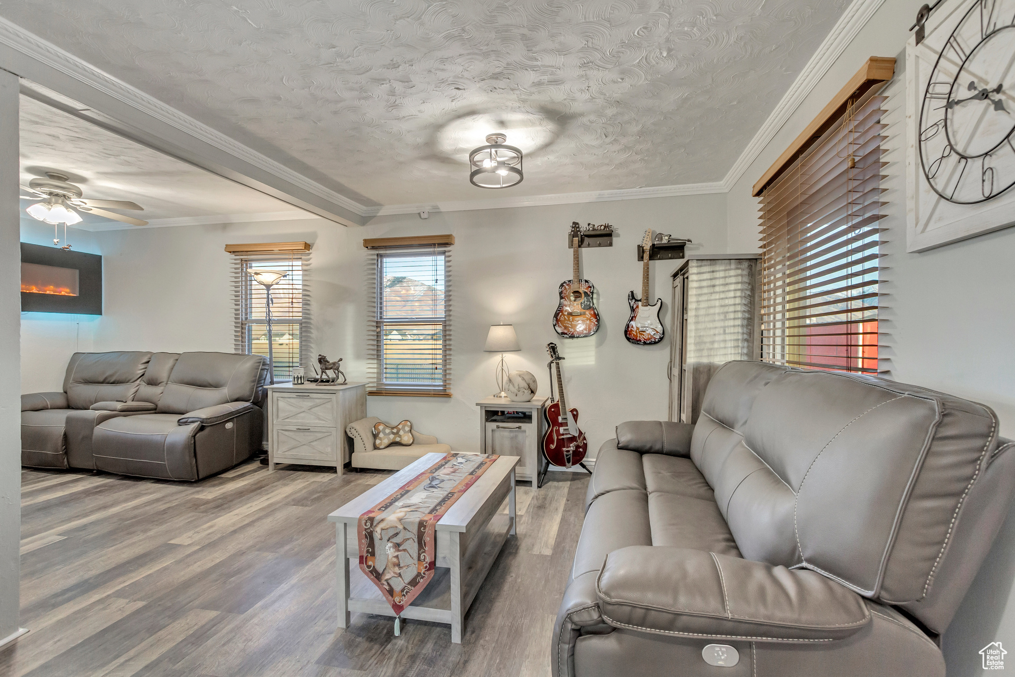 Family room featuring ceiling fan, LVP flooring, and crown molding