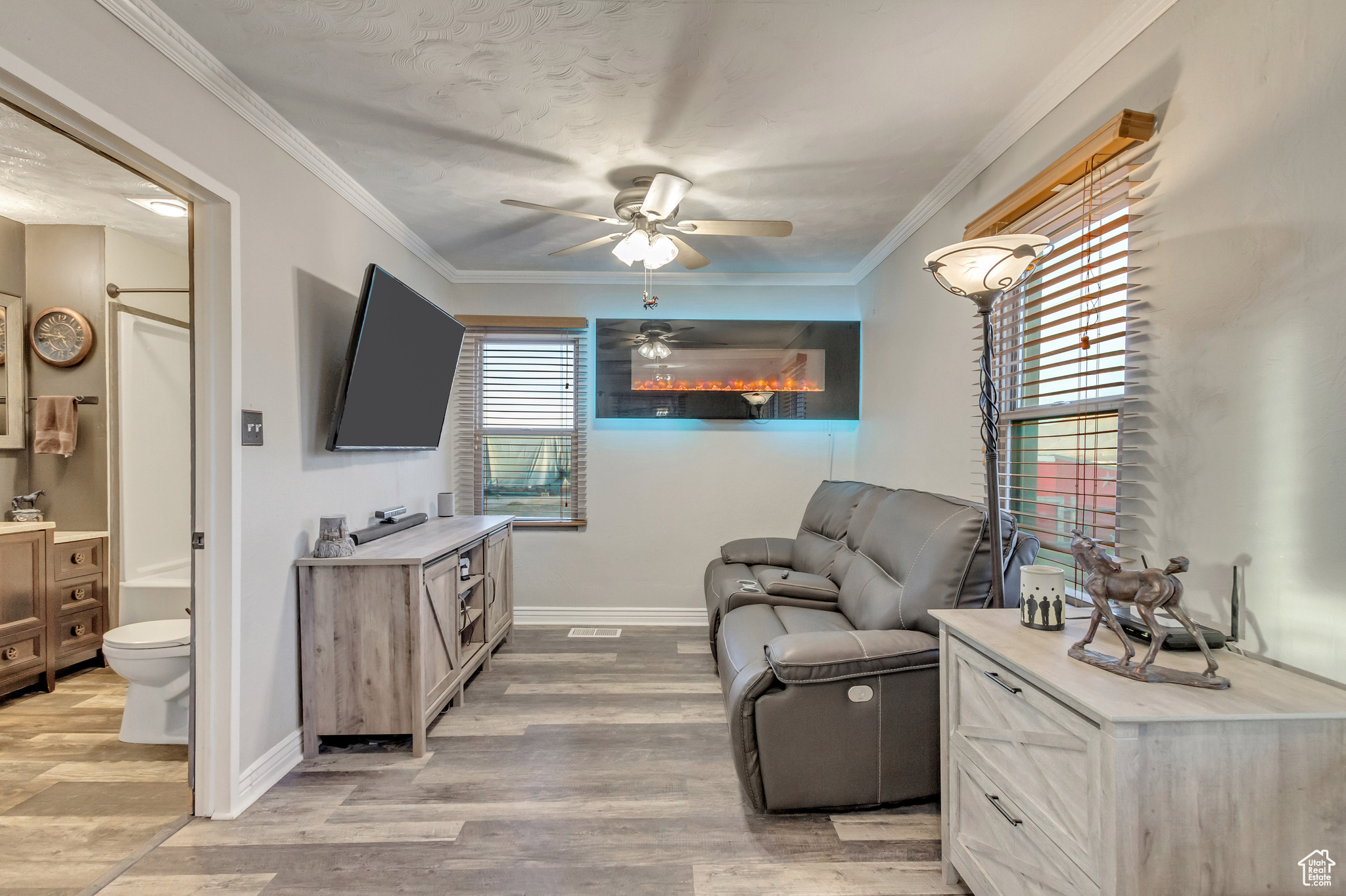 Family room featuring crown molding, ceiling fan, and LVP flooring