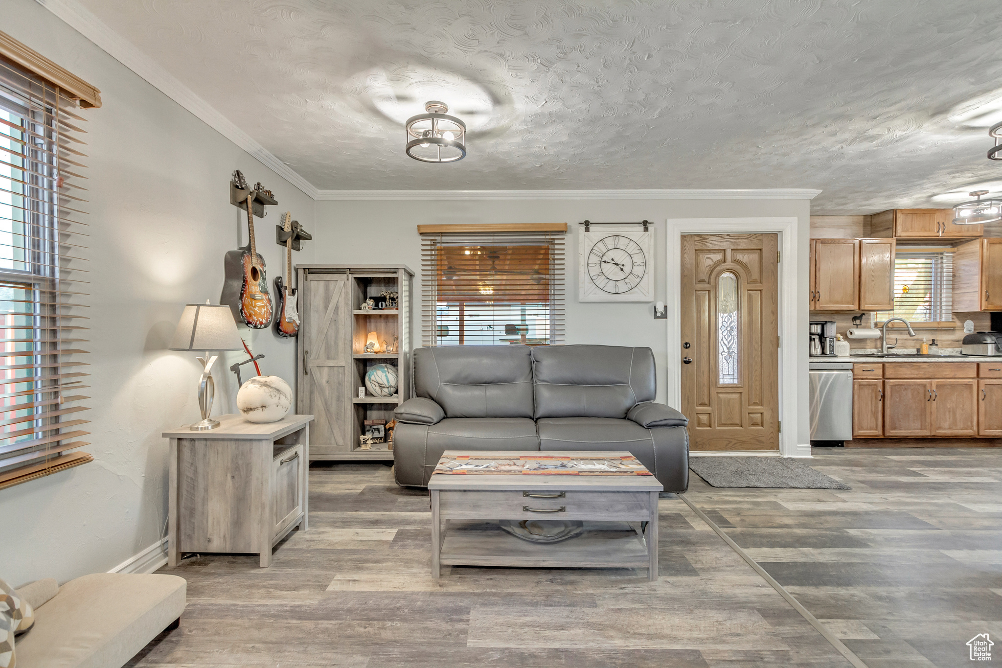 Family room featuring plenty of natural light, LVP flooring and crown molding open to kitchen