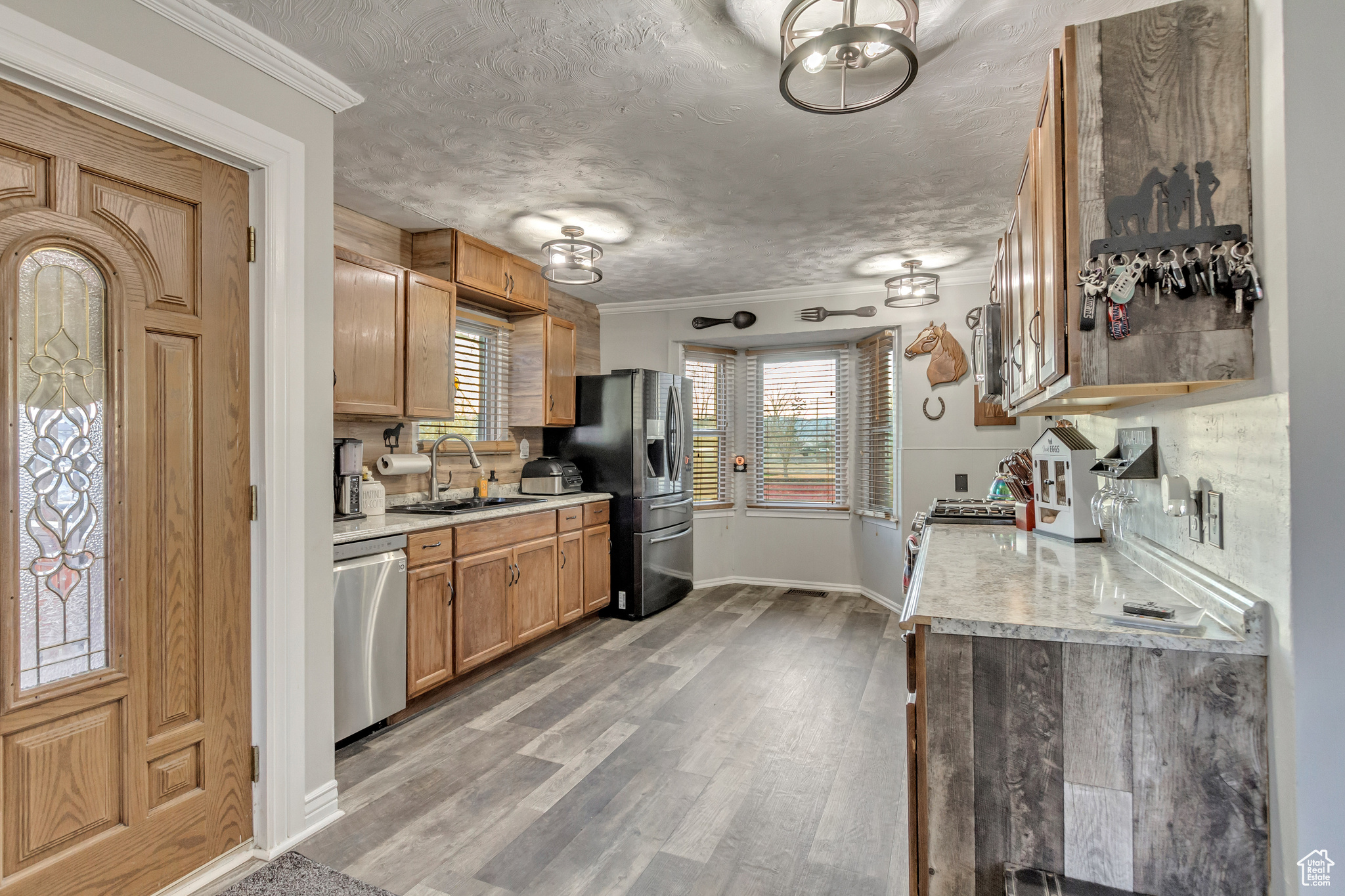 Kitchen featuring newer stainless steel appliances, crown molding, and new light fixtures