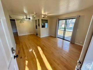 Unfurnished living room featuring ceiling fan and hardwood / wood-style floors