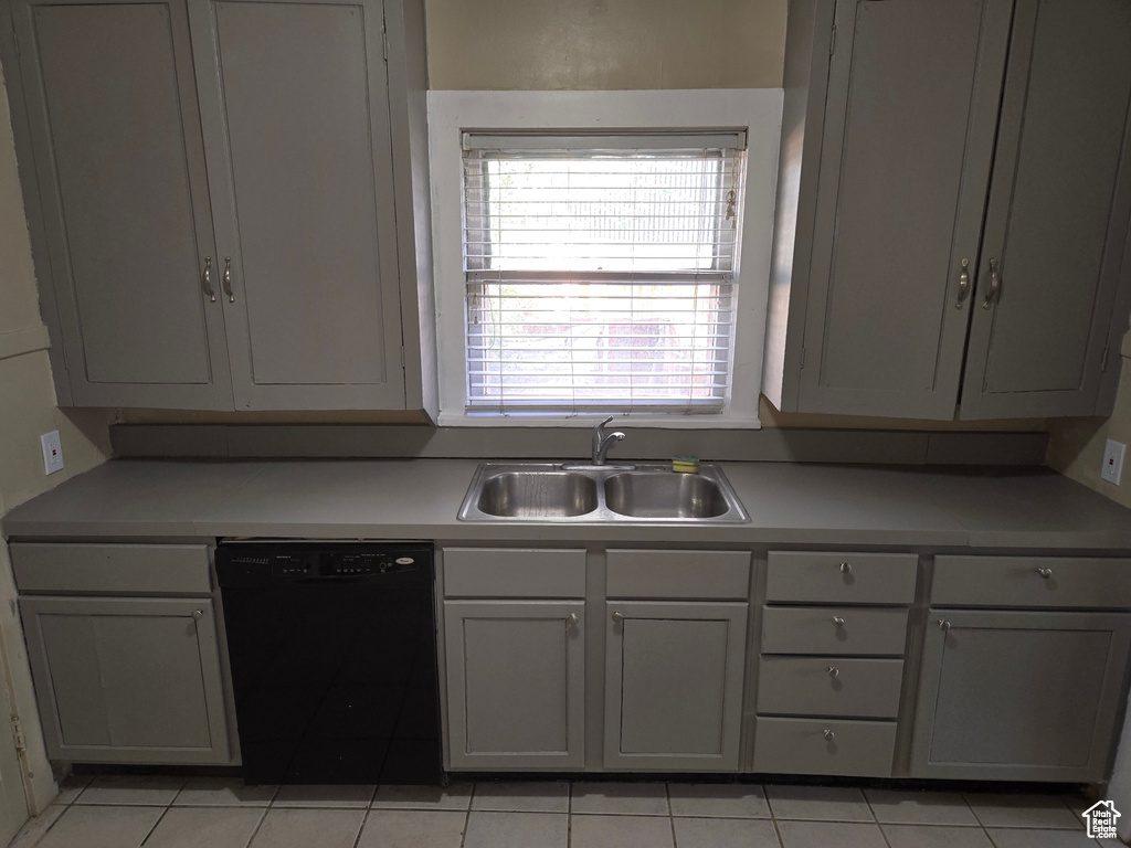 Kitchen with gray cabinets, sink, black dishwasher, and light tile patterned flooring