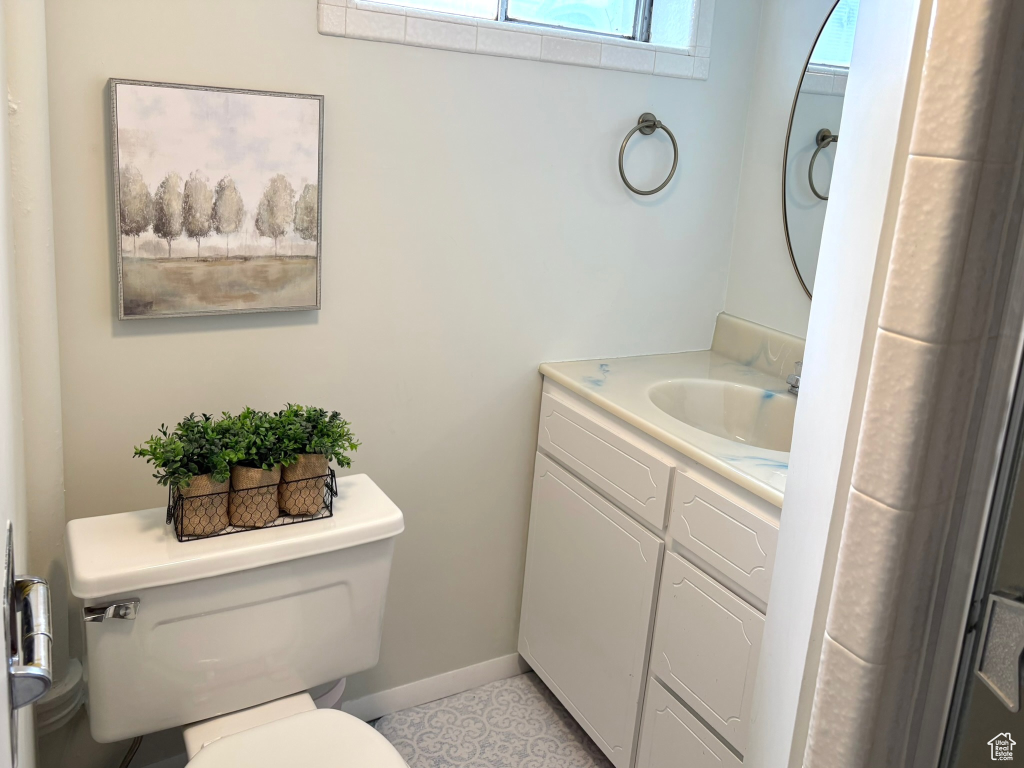 Bathroom featuring tile patterned flooring, vanity, and toilet