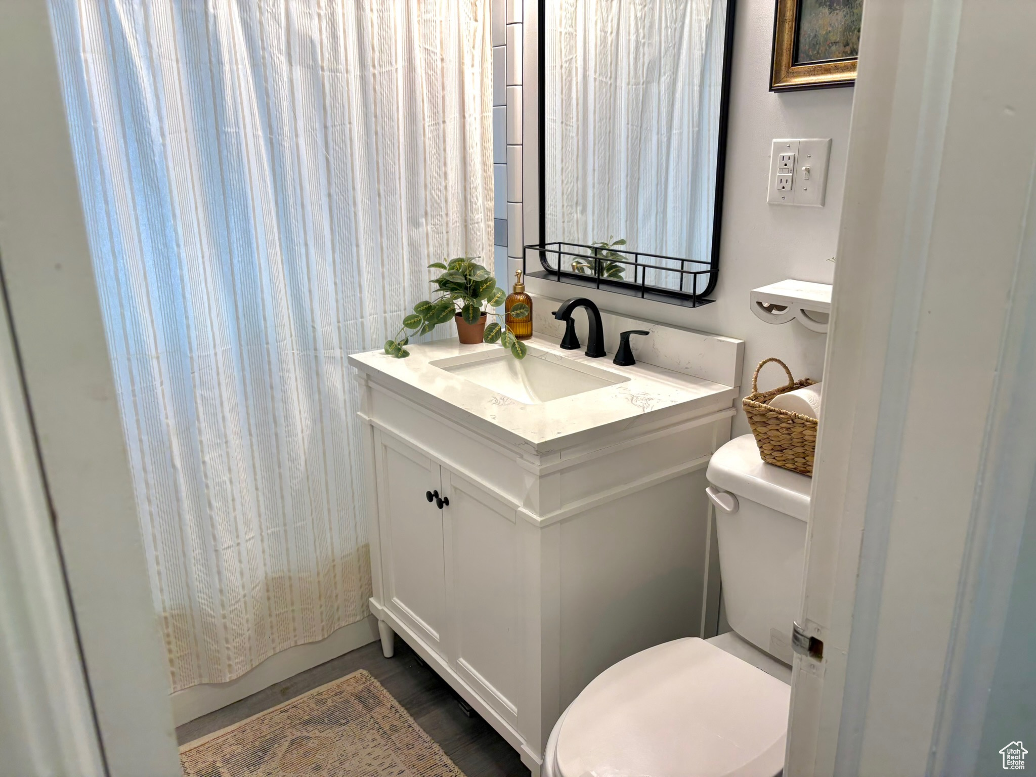 Updated bathroom with a shower with curtain, vanity, and toilet