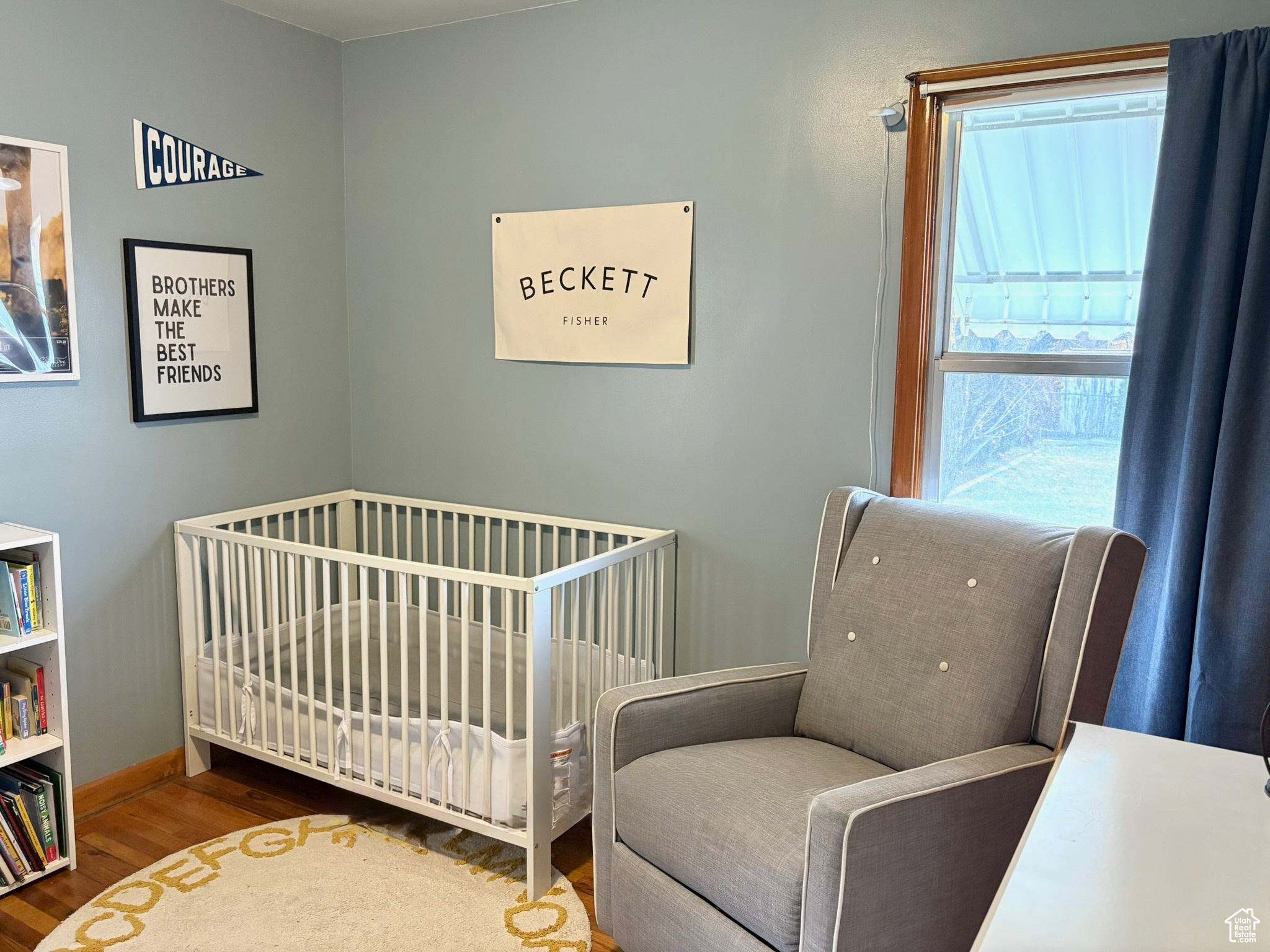 Bedroom with hardwood / wood-style flooring and a crib