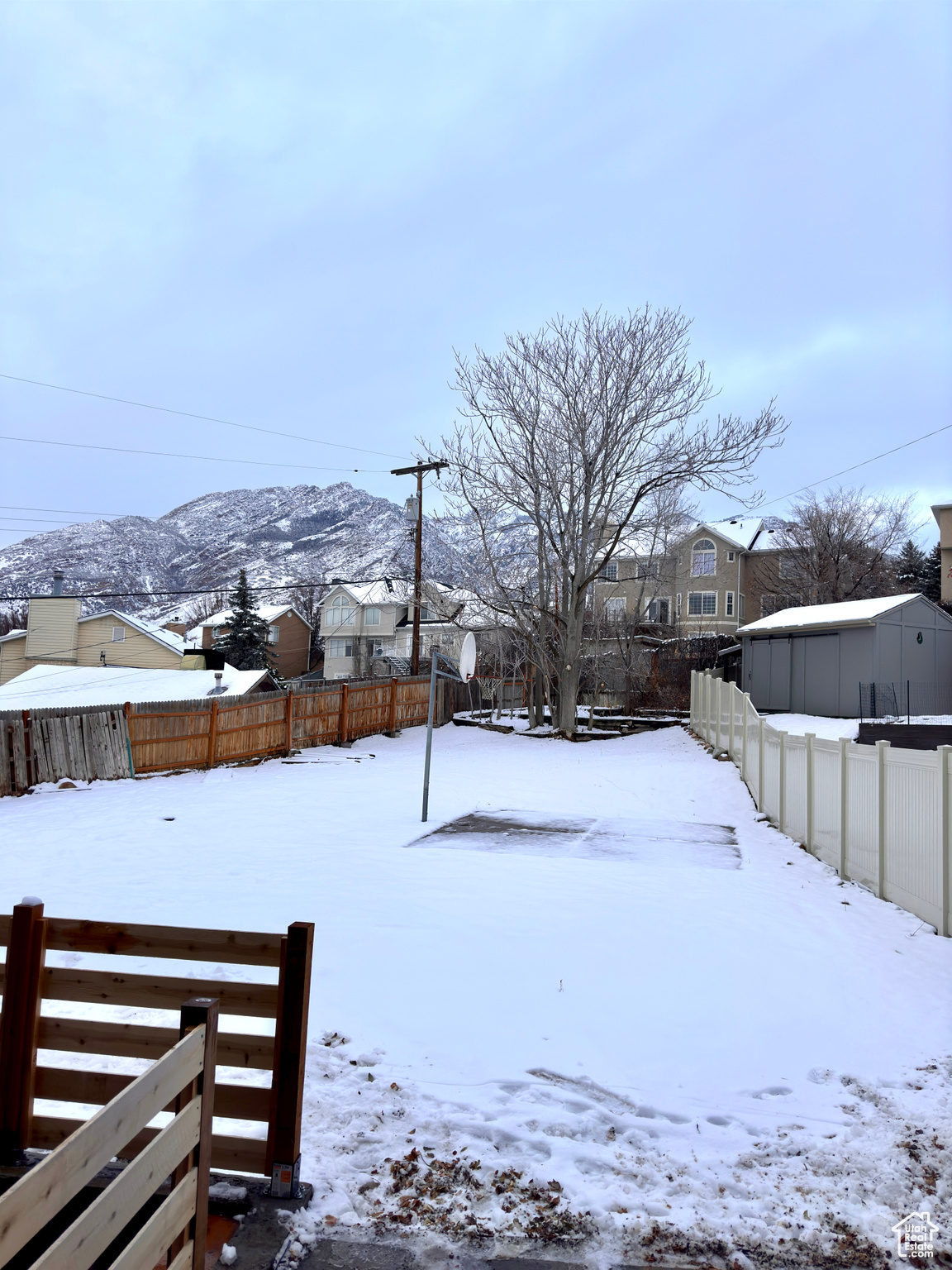 Yard layered in snow with a mountain view