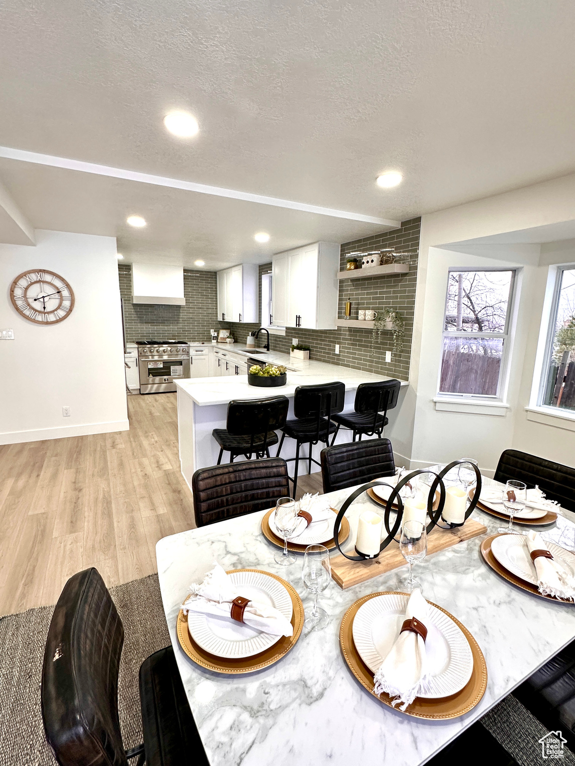 Dining space featuring sink, light wood-type flooring, and a textured ceiling