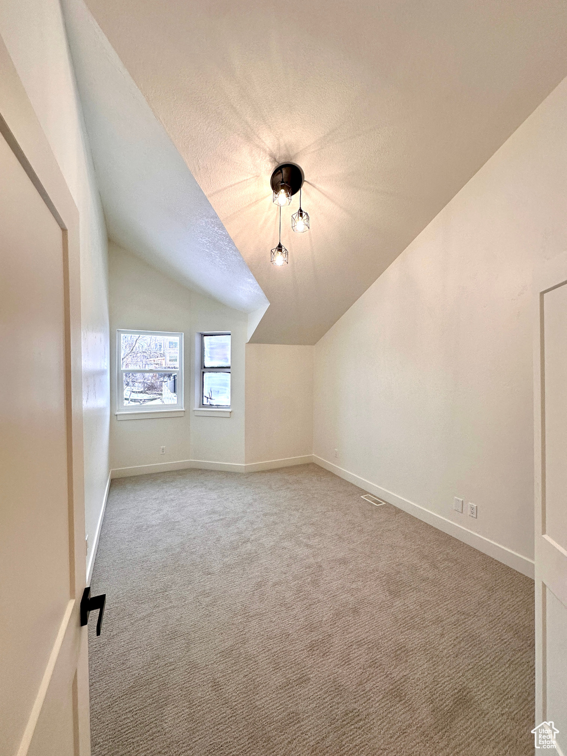 Bonus room featuring a textured ceiling, carpet floors, and lofted ceiling