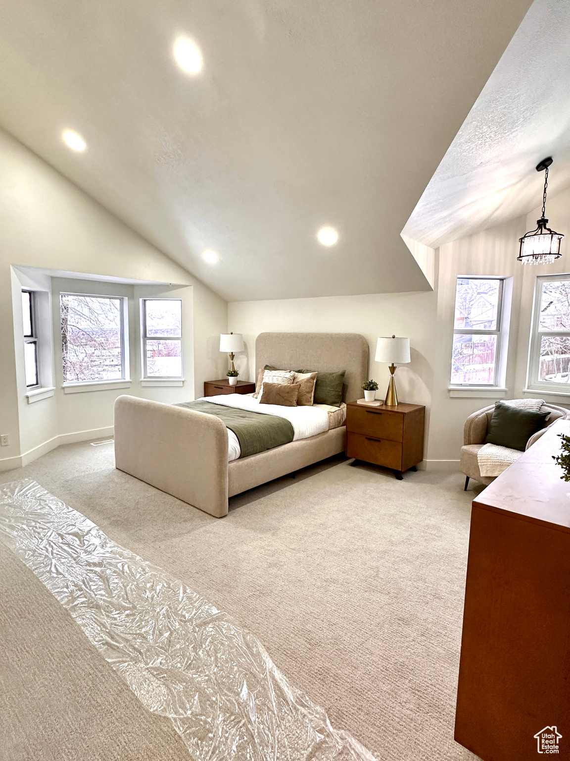 Bedroom with light carpet and vaulted ceiling