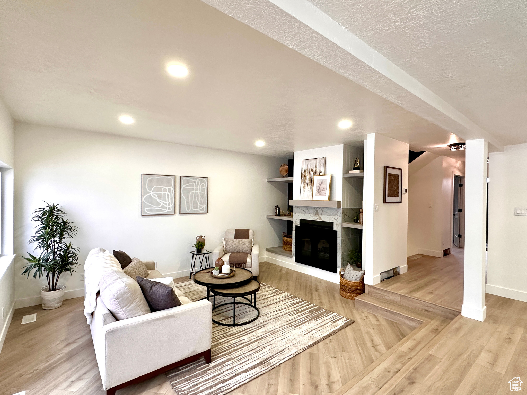 Living room featuring a fireplace, light hardwood / wood-style floors, and a textured ceiling