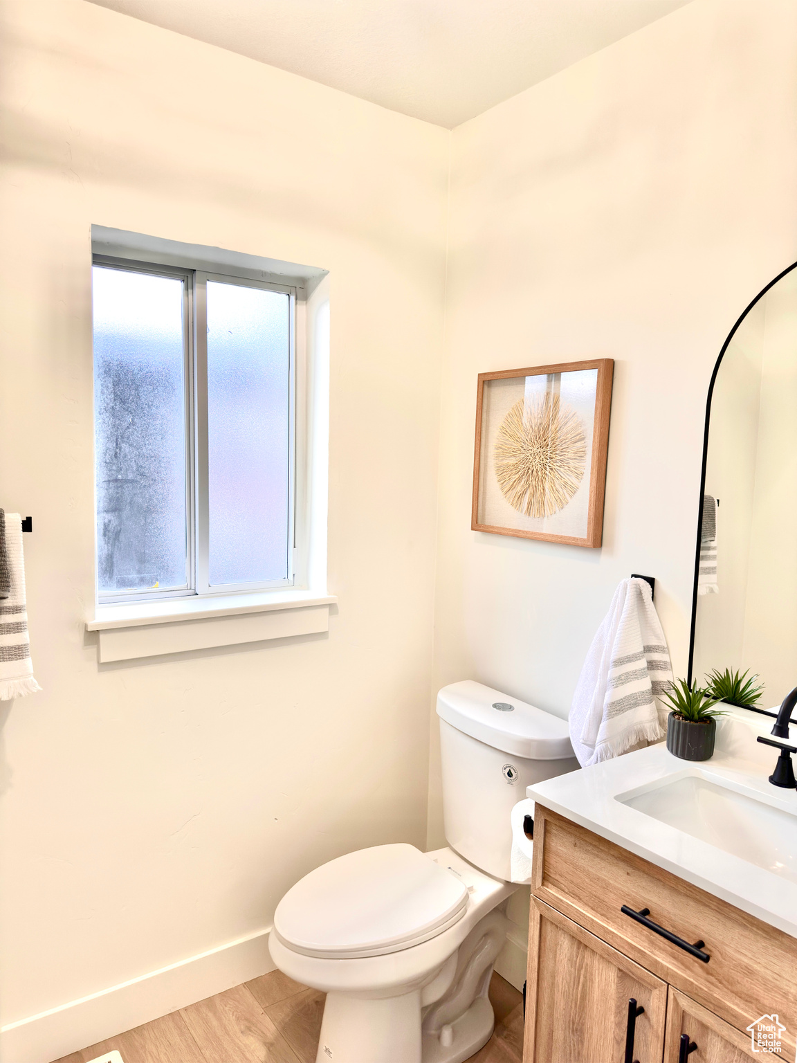 Bathroom featuring hardwood / wood-style flooring, vanity, and toilet