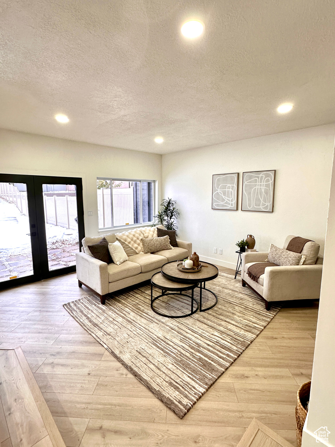 Living room with hardwood / wood-style flooring, a textured ceiling, and french doors