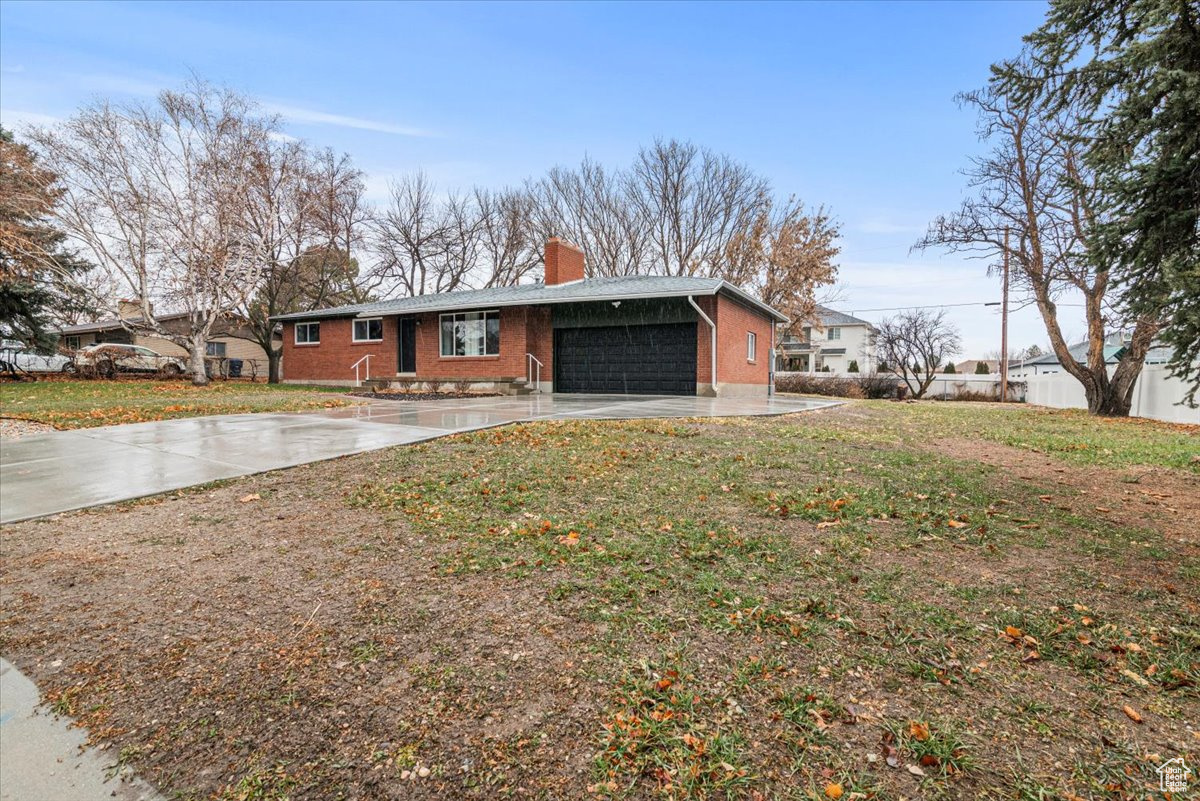 Ranch-style home with a front lawn and a garage